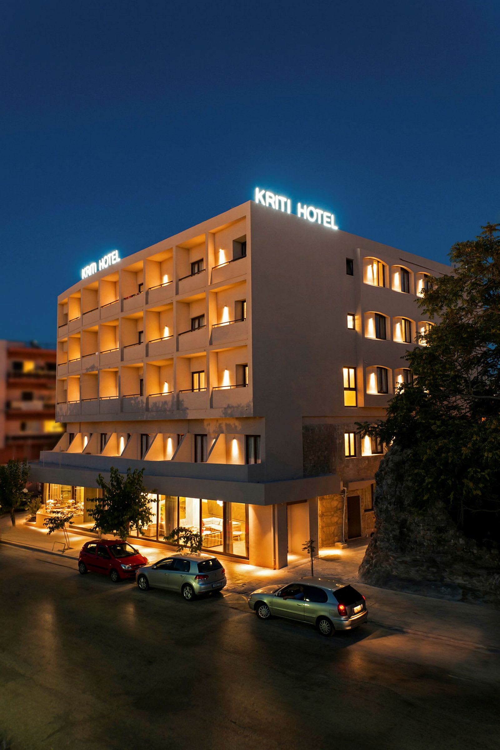 Hotellirakennus yöllä, valaistu kyltti ja julkisivu. (Tekoälyn luoma teksti)