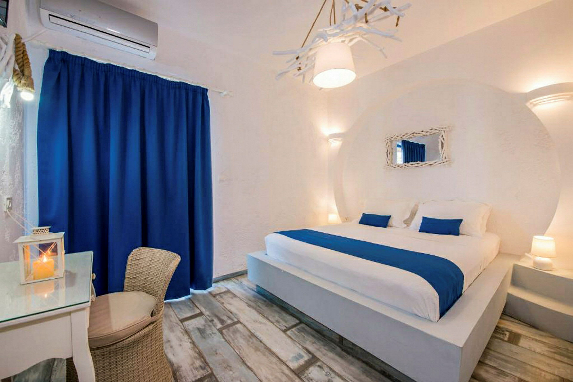 Hotellihuone, jossa suuri sänky ja sinivalkoiset yksityiskohdat. (Tekoälyn luoma teksti)