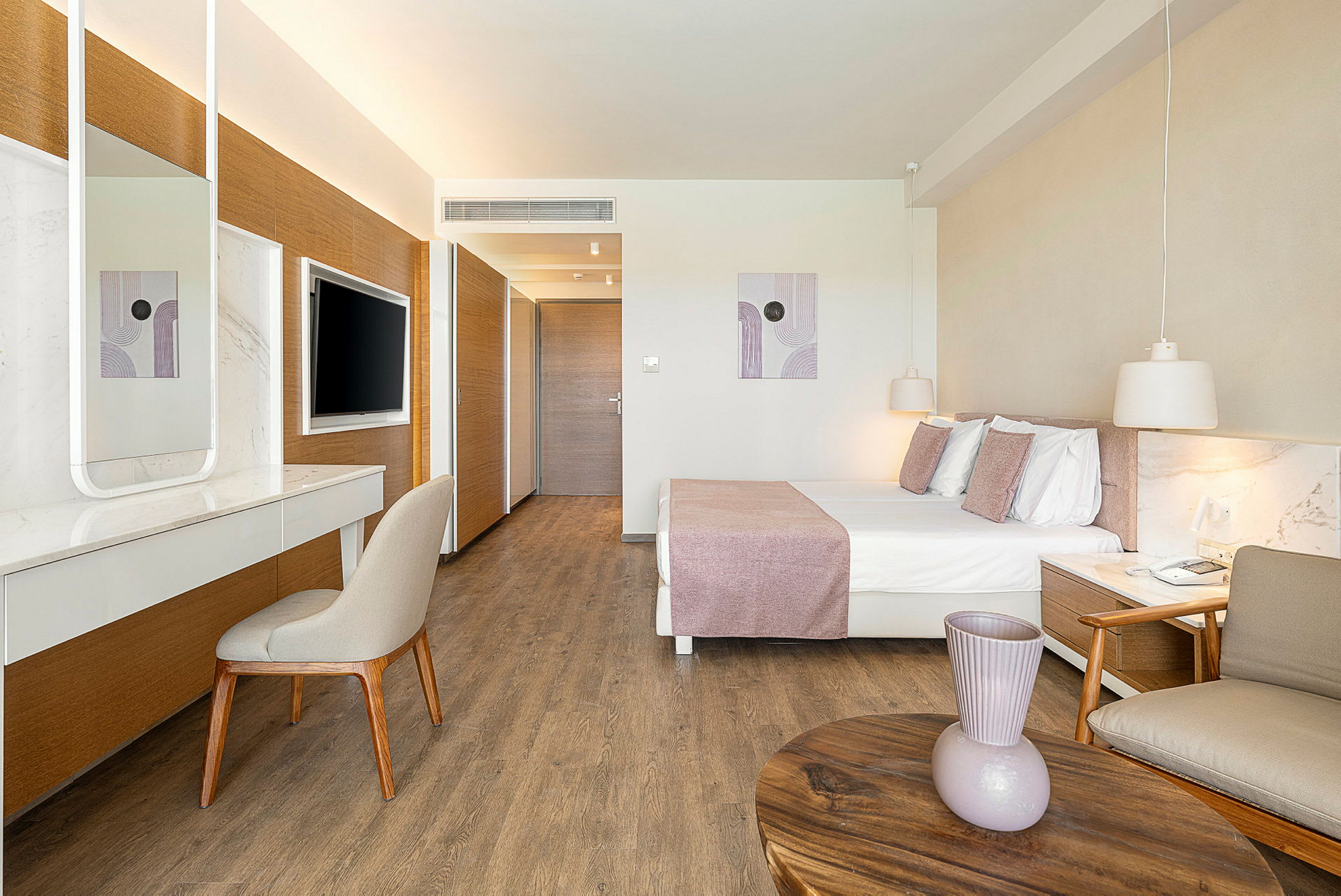 Kuva nykyaikaisesta hotellihuoneesta, jossa on parivuode, kirjoituspöytä ja seinään kiinnitetty televisio. (Tekoälyn luoma teksti)