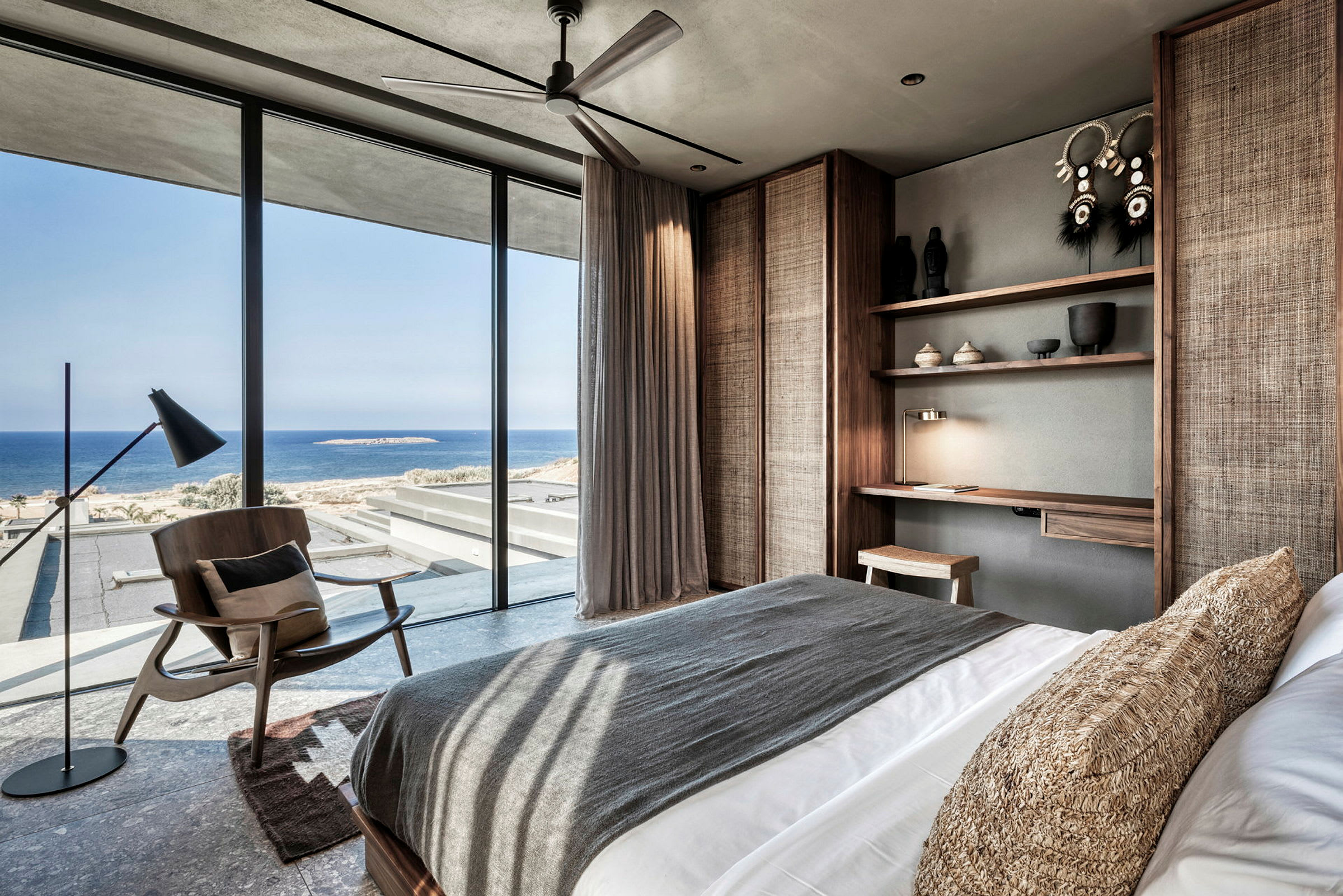 Moderni hotellihuone, josta on merinäköala suurten ikkunoiden läpi. (Tekoälyn luoma teksti)