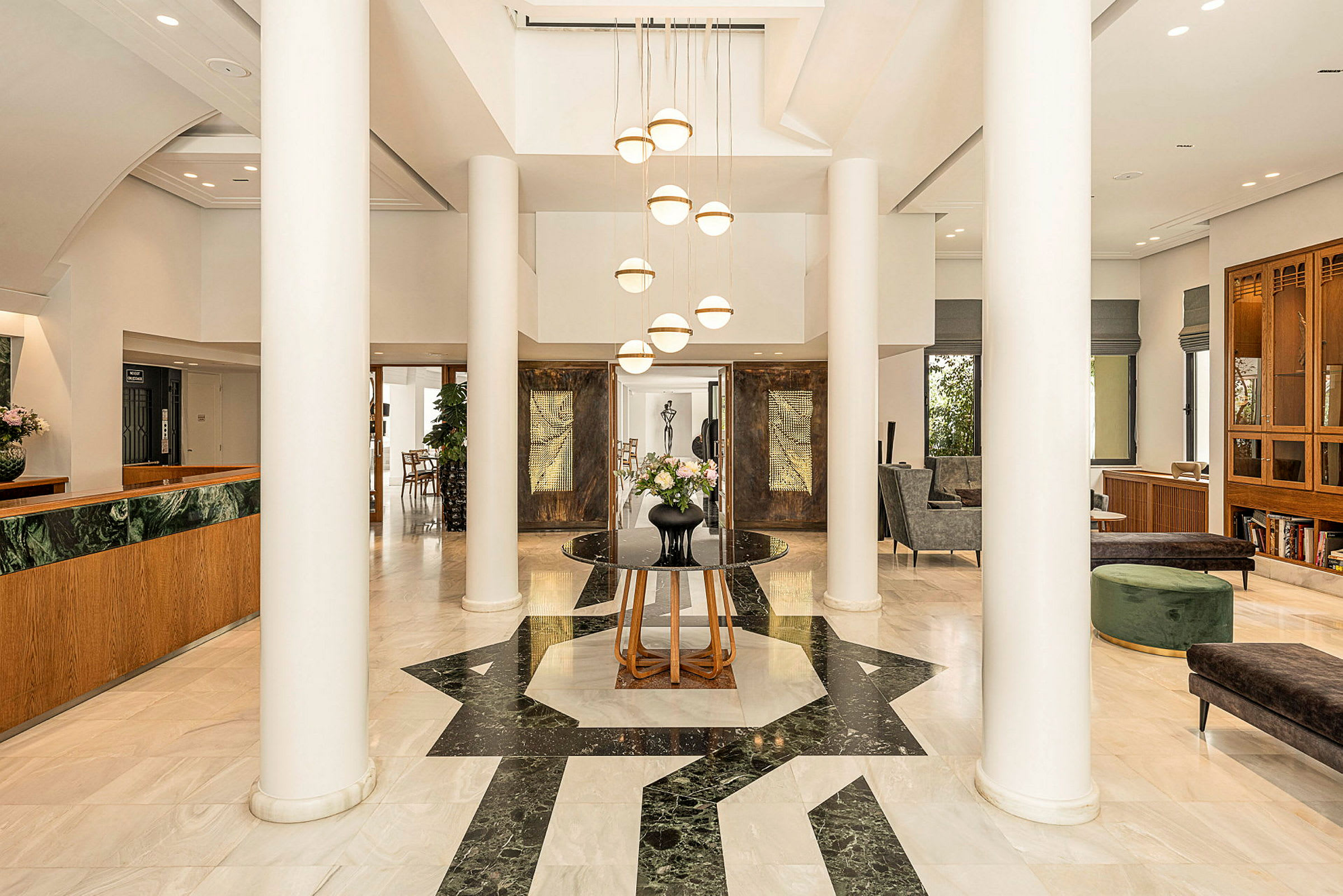 Tyylikäs hotellin aula pylväiden ja istuinalueiden kanssa. (Tekoälyn luoma teksti)
