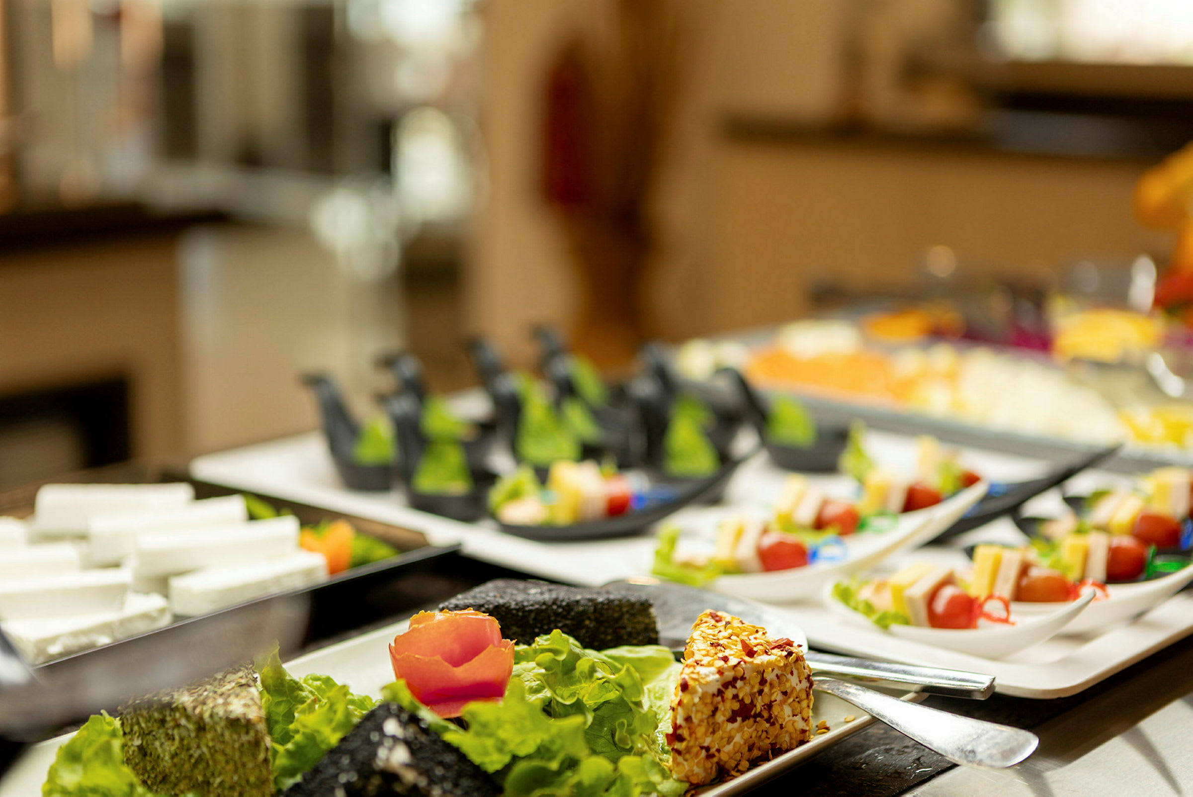 Buffet, jossa erilaisia kauniisti aseteltuja pikkuannoksia lautasilla. (Tekoälyn luoma teksti)