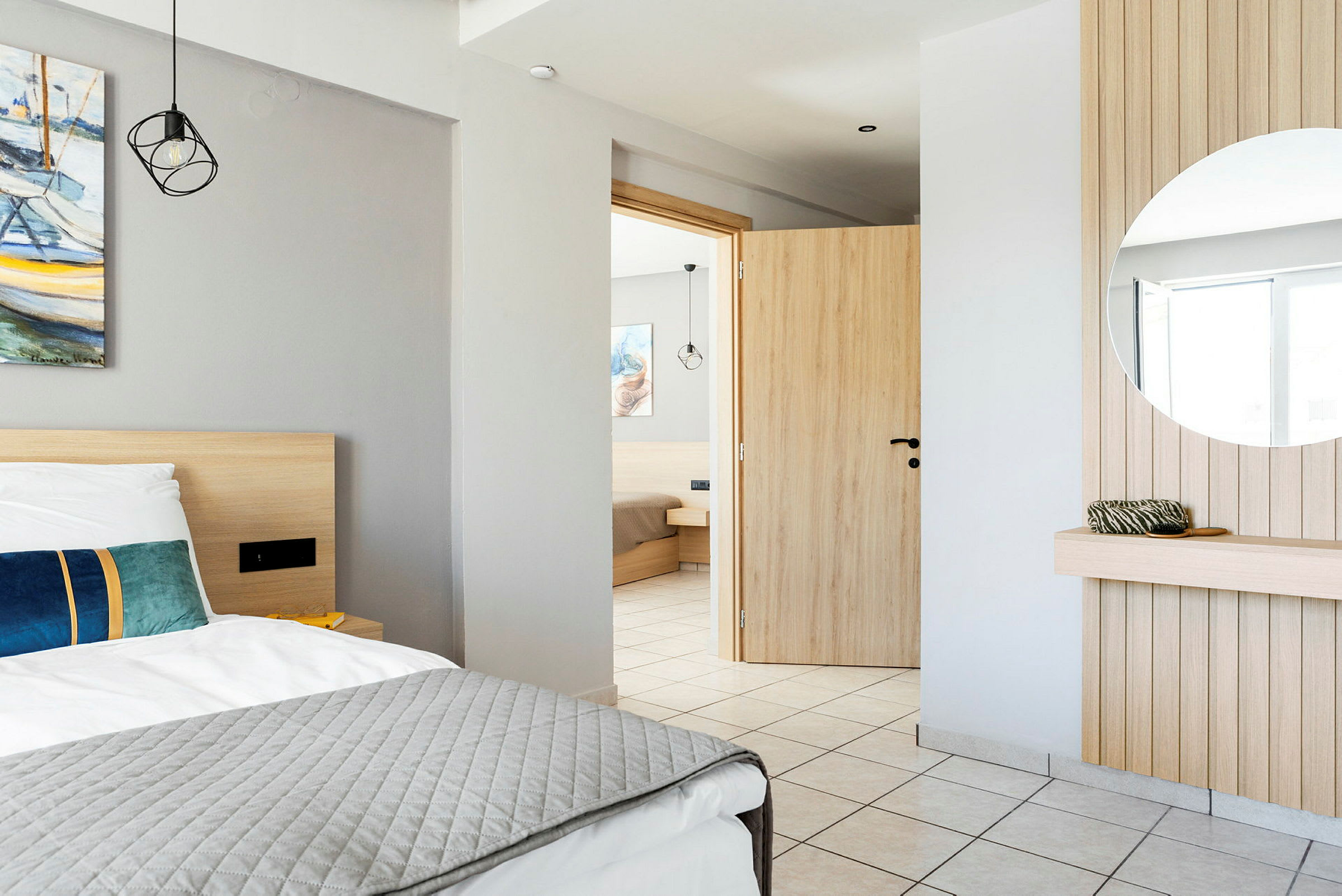 Hotellihuoneen sisustus, jossa on sänky, peili ja avattu ovi. (Tekoälyn luoma teksti)