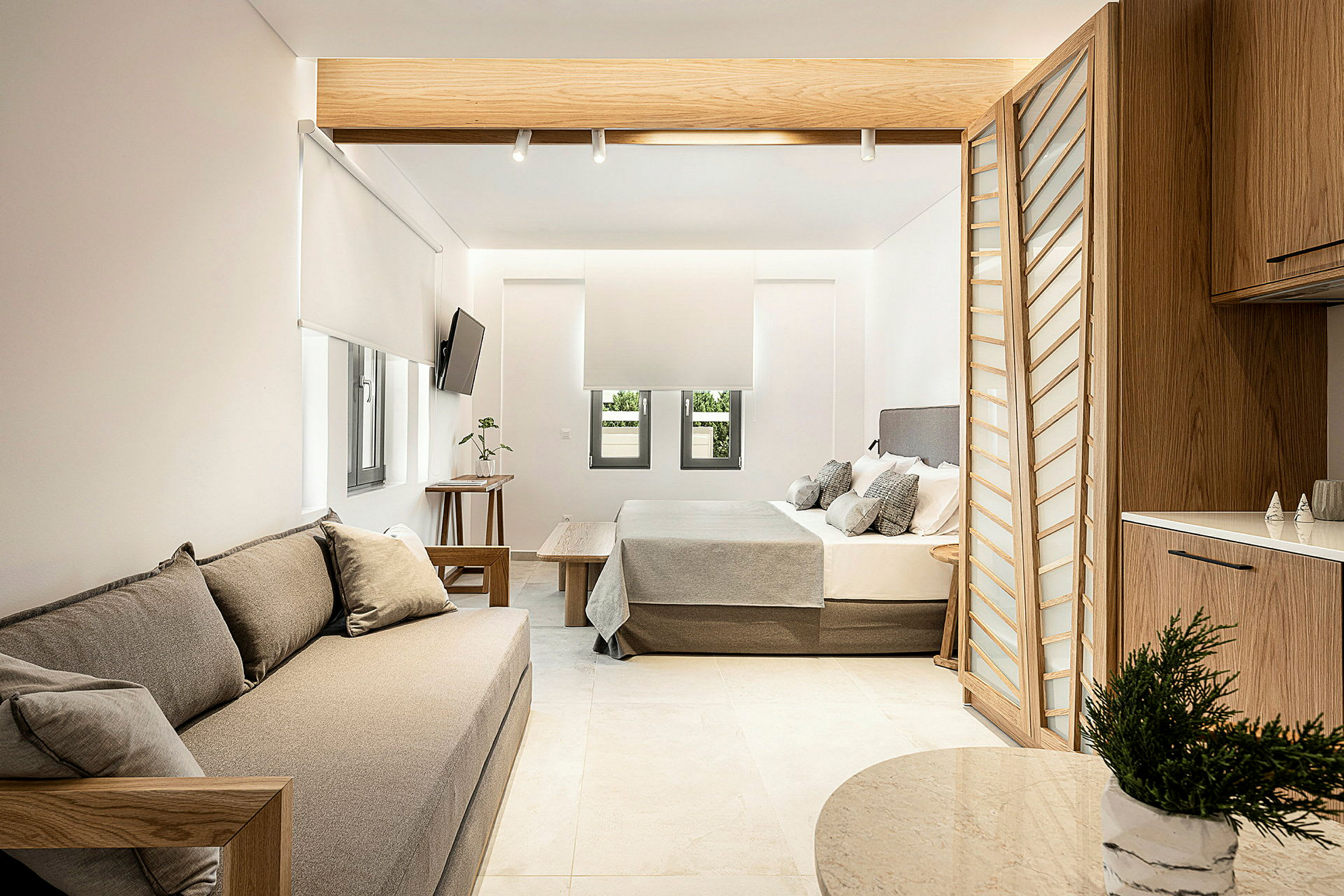 Nykyaikaisesti sisustettu hotellihuone, jossa on istuimet, sänky ja keittiötila. (Tekoälyn luoma teksti)