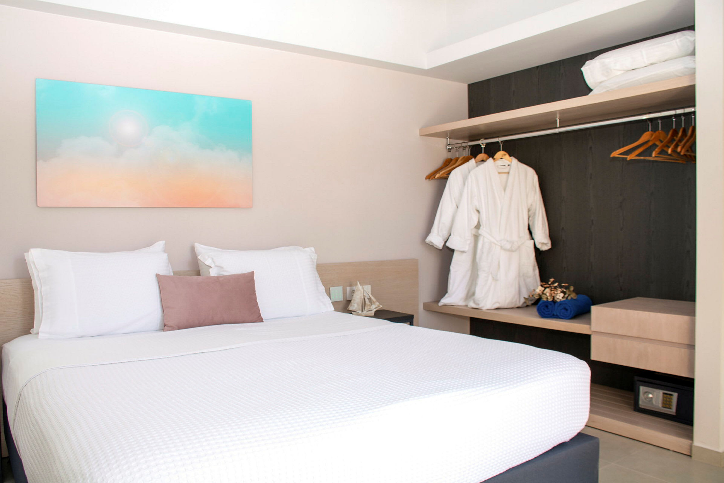 Hotellihuone, jossa parivuode, seinätaidetta ja vaatekaappi. (Tekoälyn luoma teksti)