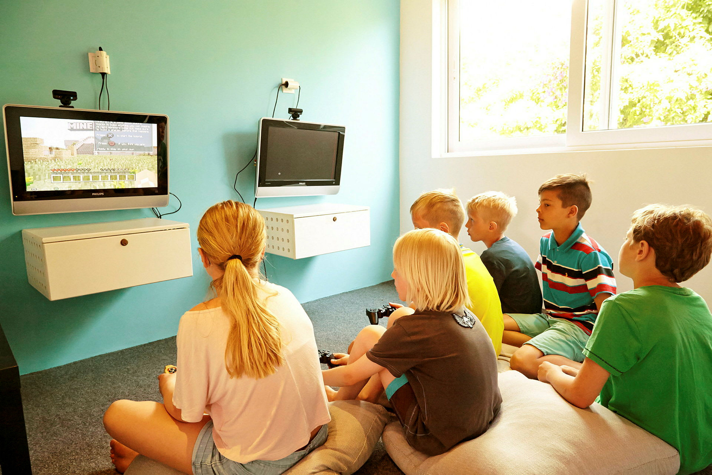 Lapset pelaavat televisiopeliä valoisassa huoneessa. (Tekoälyn luoma teksti)