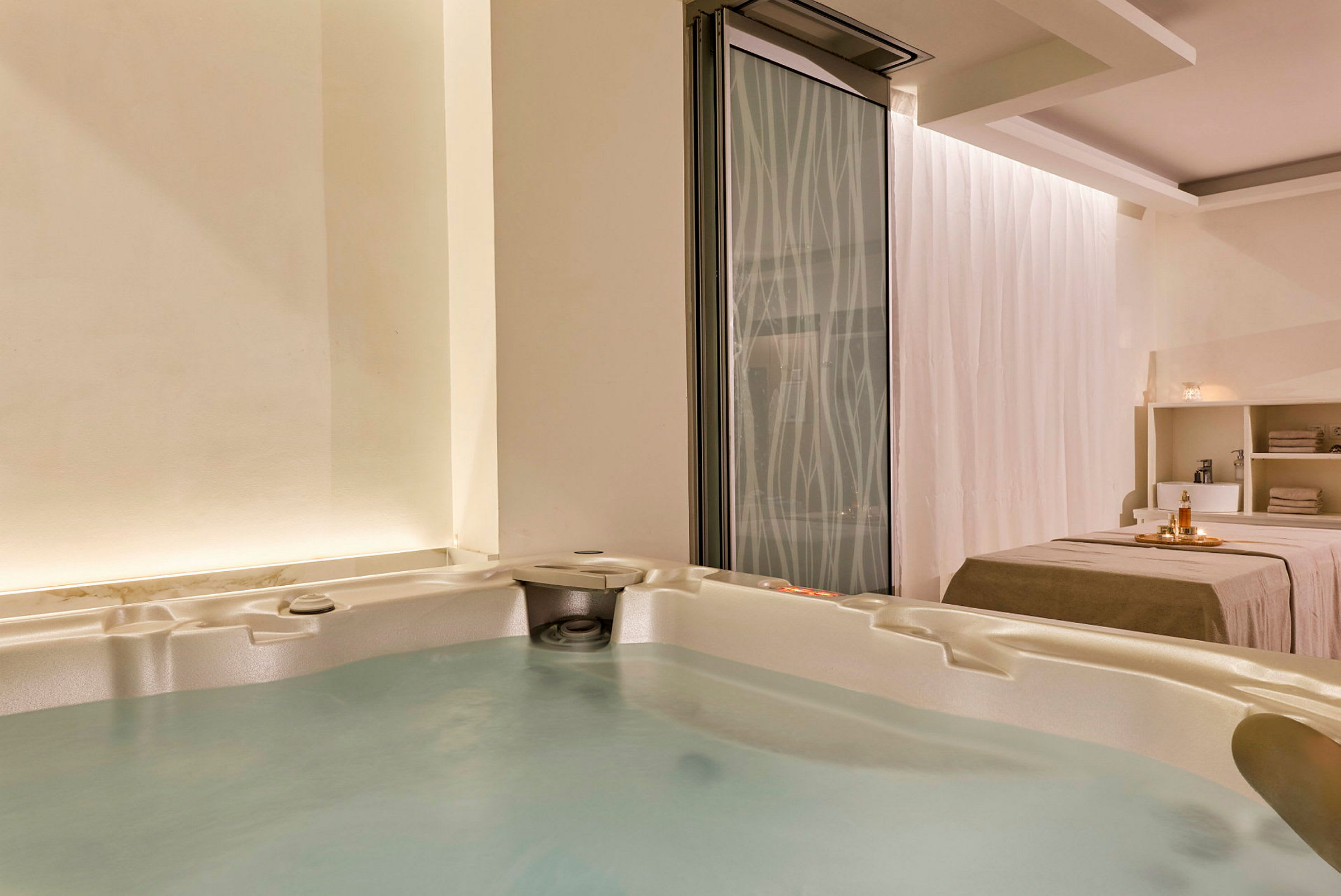 Spa-huone, jossa on poreallas ja hoitopöytä. (Tekoälyn luoma teksti)