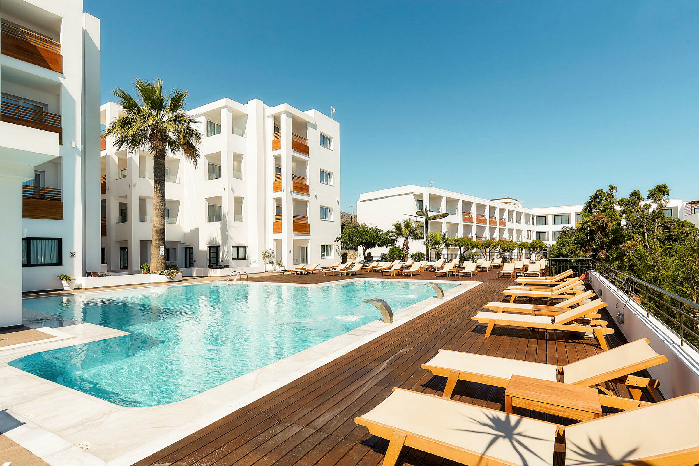 Hotellialue, jossa uima-allas ja aurinkotuoleja. (Tekoälyn luoma teksti)
