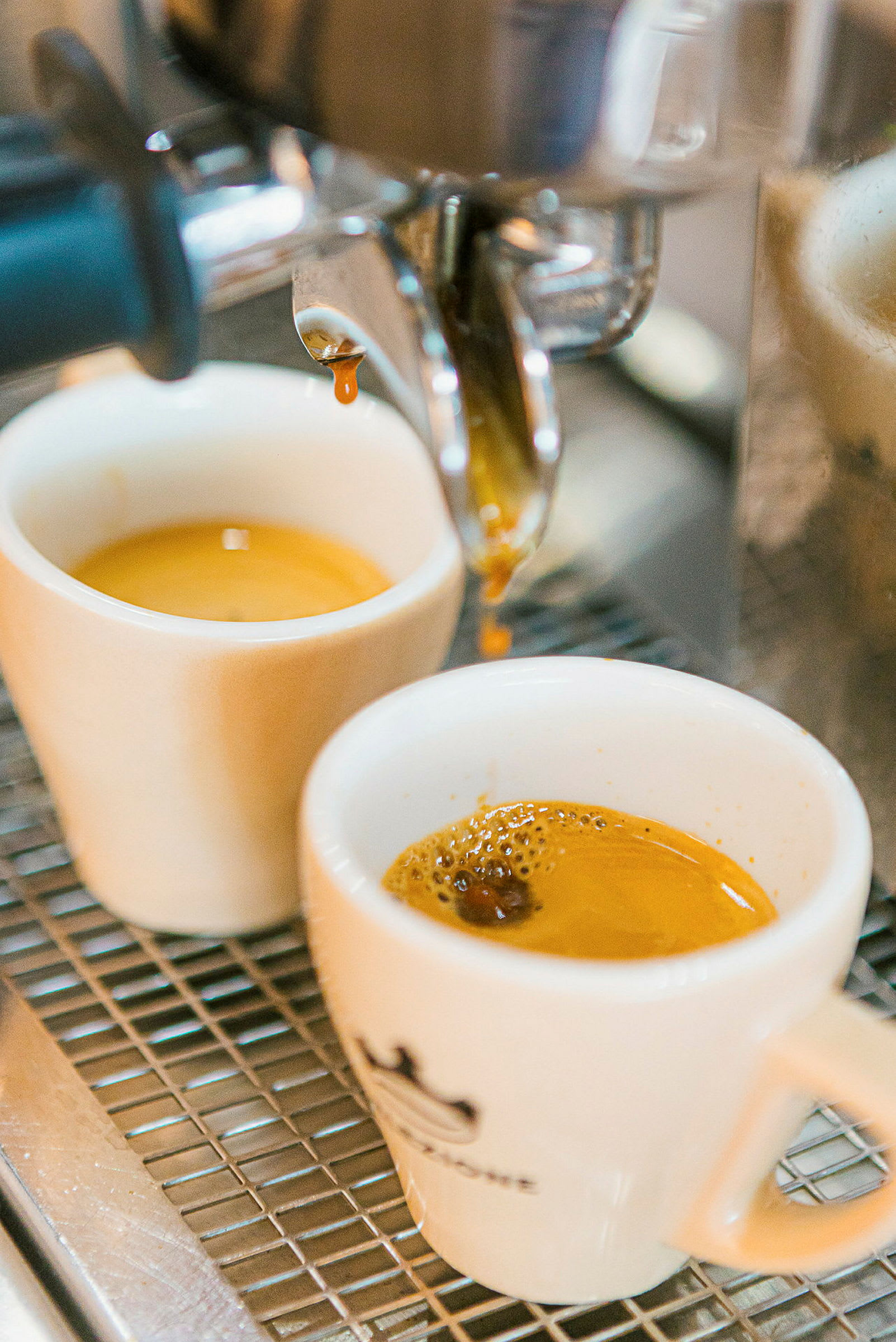 Espresso valmistuu kahdessa valkoisessa kupissa koneen alla. (Tekoälyn luoma teksti)