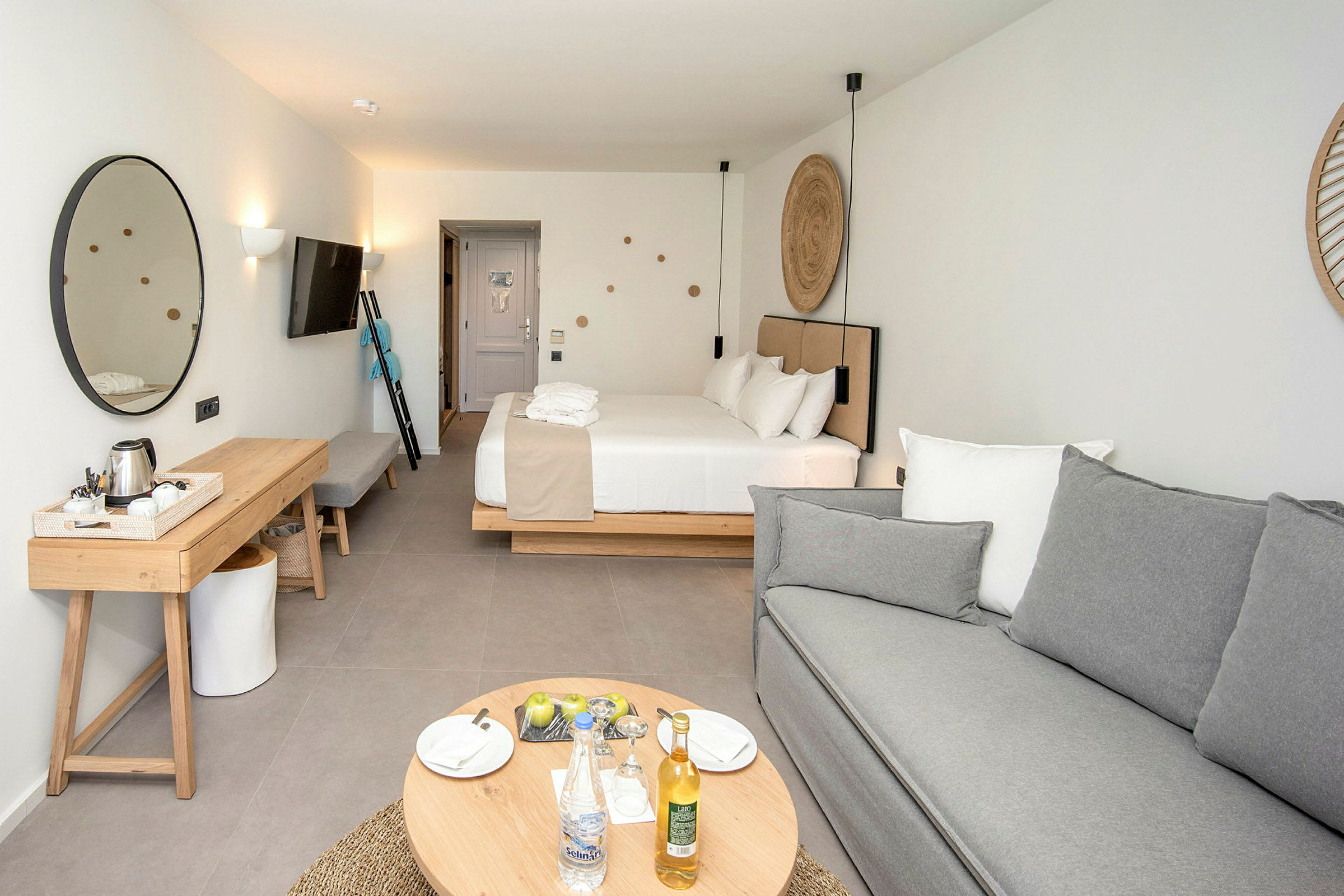 Moderni hotellihuone, jossa on sänky, sohva ja huonekaluja. (Tekoälyn luoma teksti)