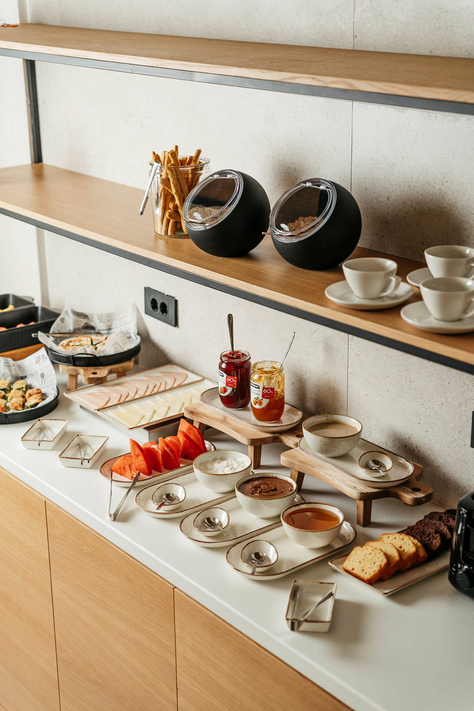 Aamiaisbuffet, jossa leipää, marmeladia ja hedelmiä. (Tekoälyn luoma teksti)