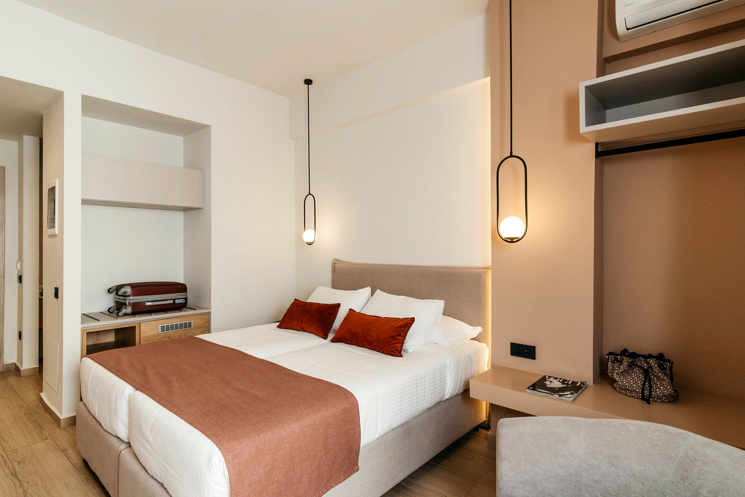 Moderni hotellihuone, jossa on parivuode ja tyylikkäät riippuvalaisimet. (Tekoälyn luoma teksti)