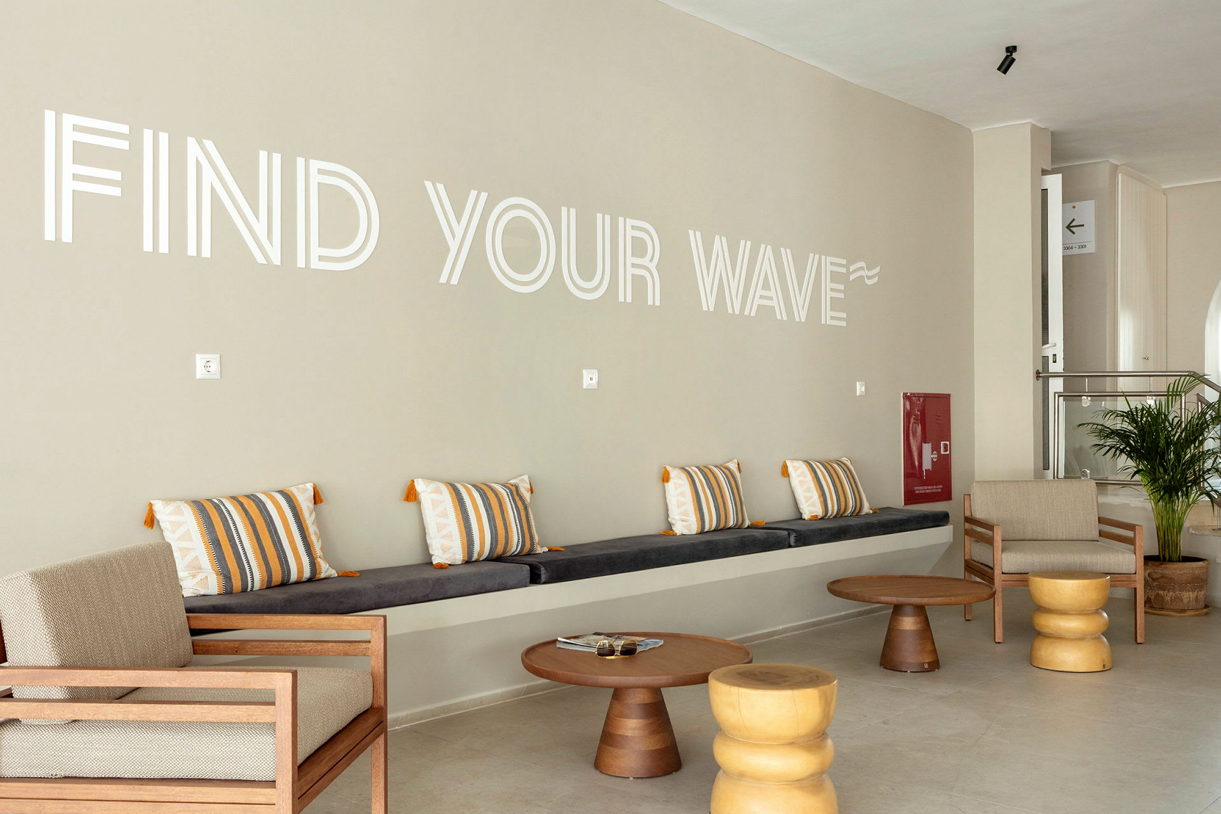 Aulan oleskelutila, jossa istumapaikkoja ja seinällä teksti 'Find Your Wave'. (Tekoälyn luoma teksti)