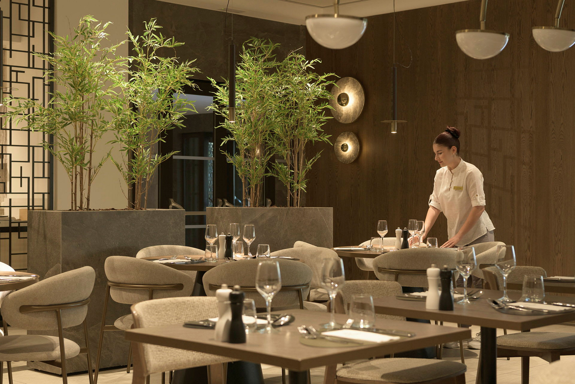 Tyylikäs ravintola, jossa on modernit huonekalut ja elävät vihreät kasvit. (Tekoälyn luoma teksti)
