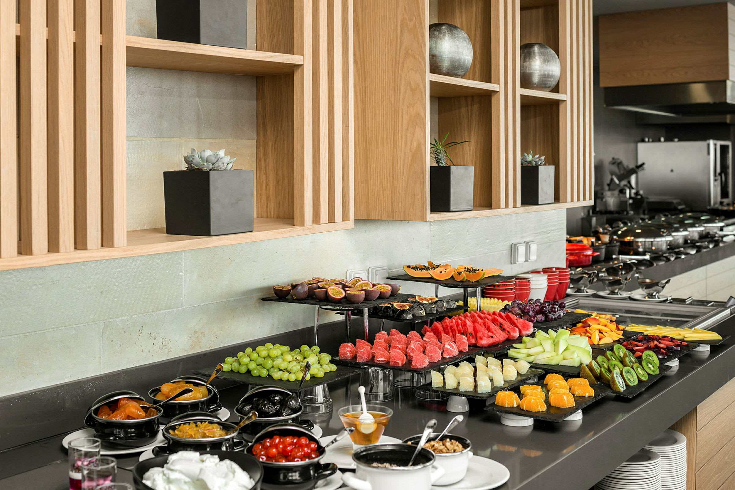 Buffet, jossa on erilaisia tuoreita hedelmiä ja lisukkeita, sijoitettuna tyylikkääseen tilaan. (Tekoälyn luoma teksti)