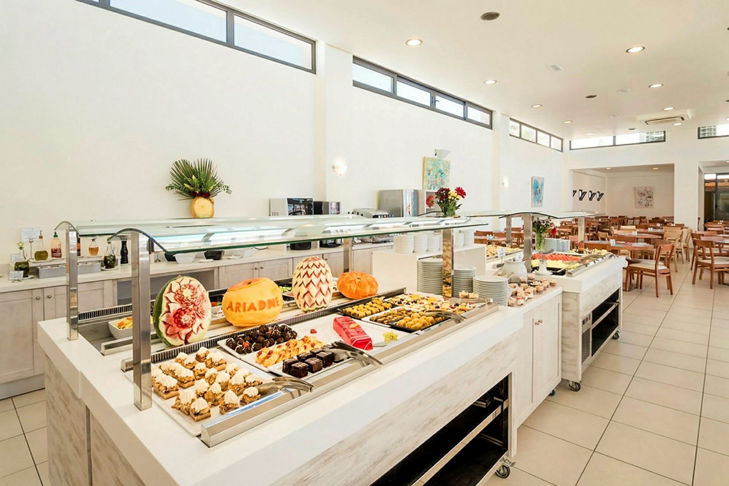 Buffet, jolla on koristeltuja meloneja ja valikoima jälkiruokia. (Tekoälyn luoma teksti)