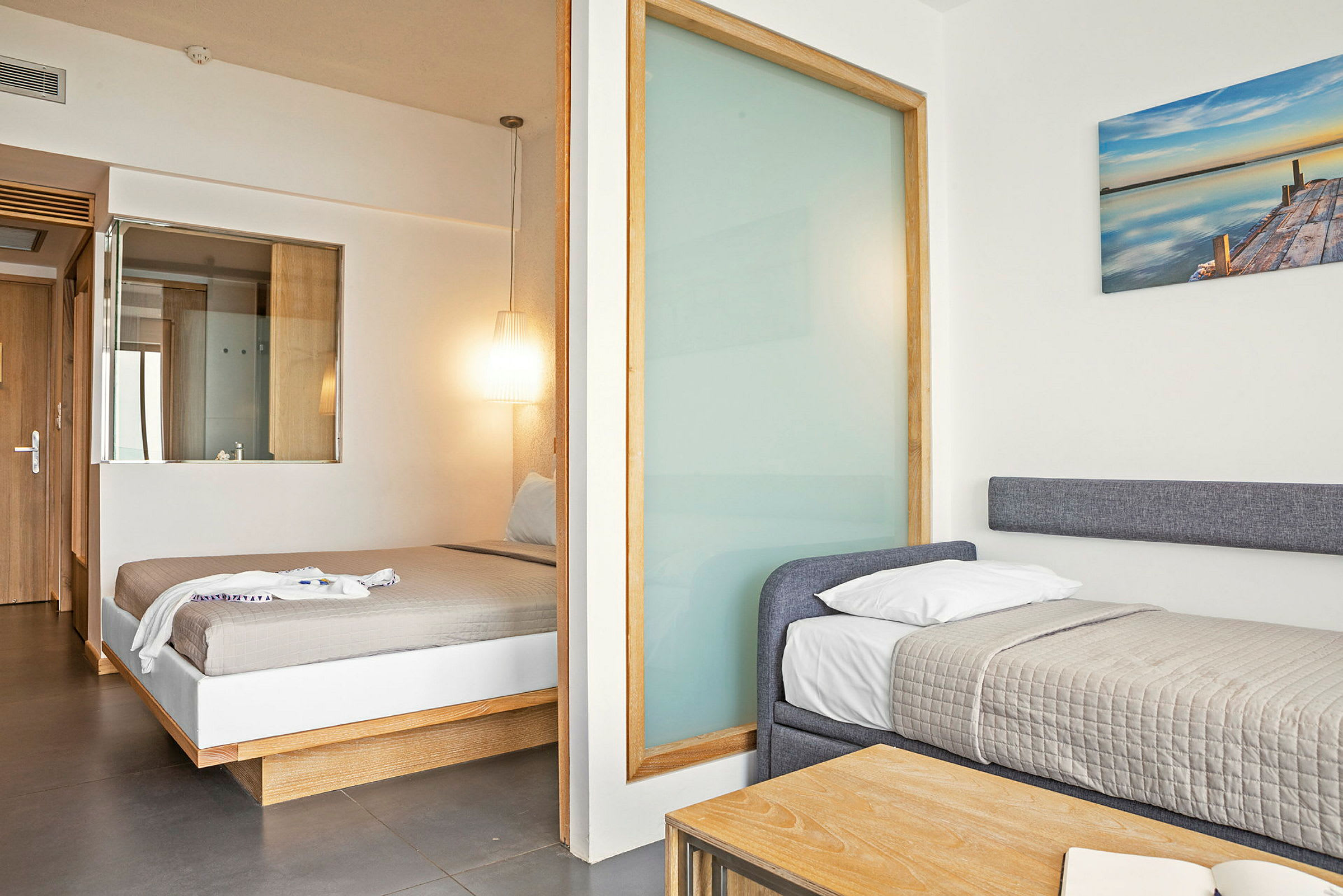 Hotellihuone, jossa on kaksi vuodetta, parivuode ja yksittäinen vuode. (Tekoälyn luoma teksti)