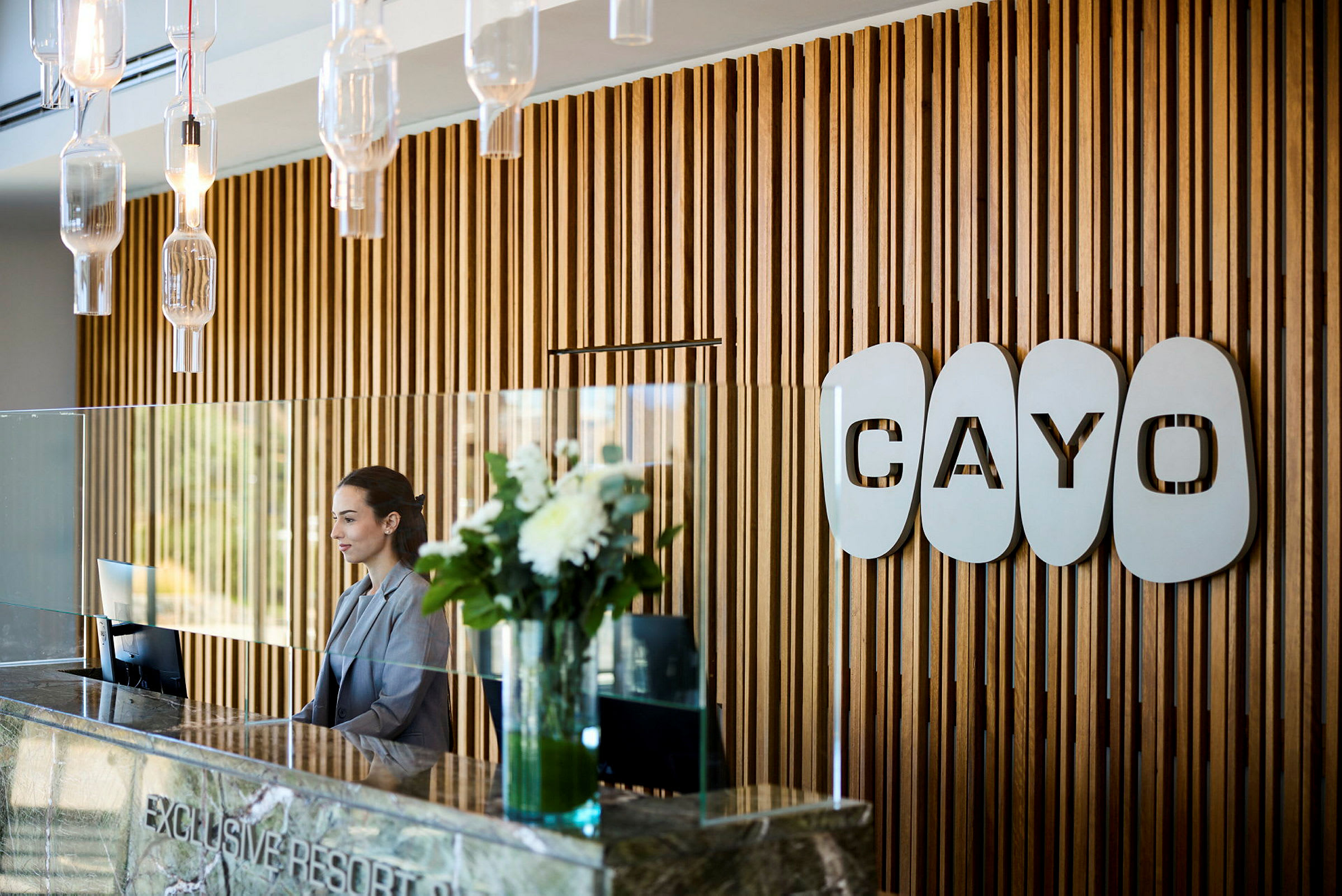 Vastaanotto, jossa puupaneeliseinä ja logo 'Cayo'. (Tekoälyn luoma teksti)
