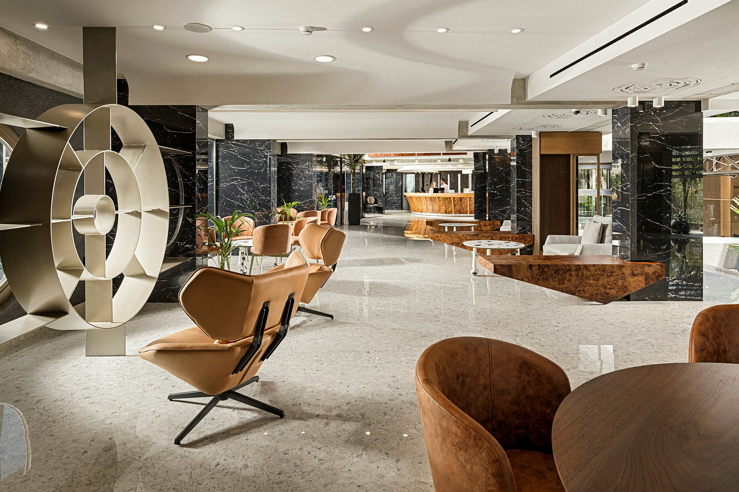 Moderni hotellin aula, jossa on designhuonekaluja ja marmorielementtejä. (Tekoälyn luoma teksti)