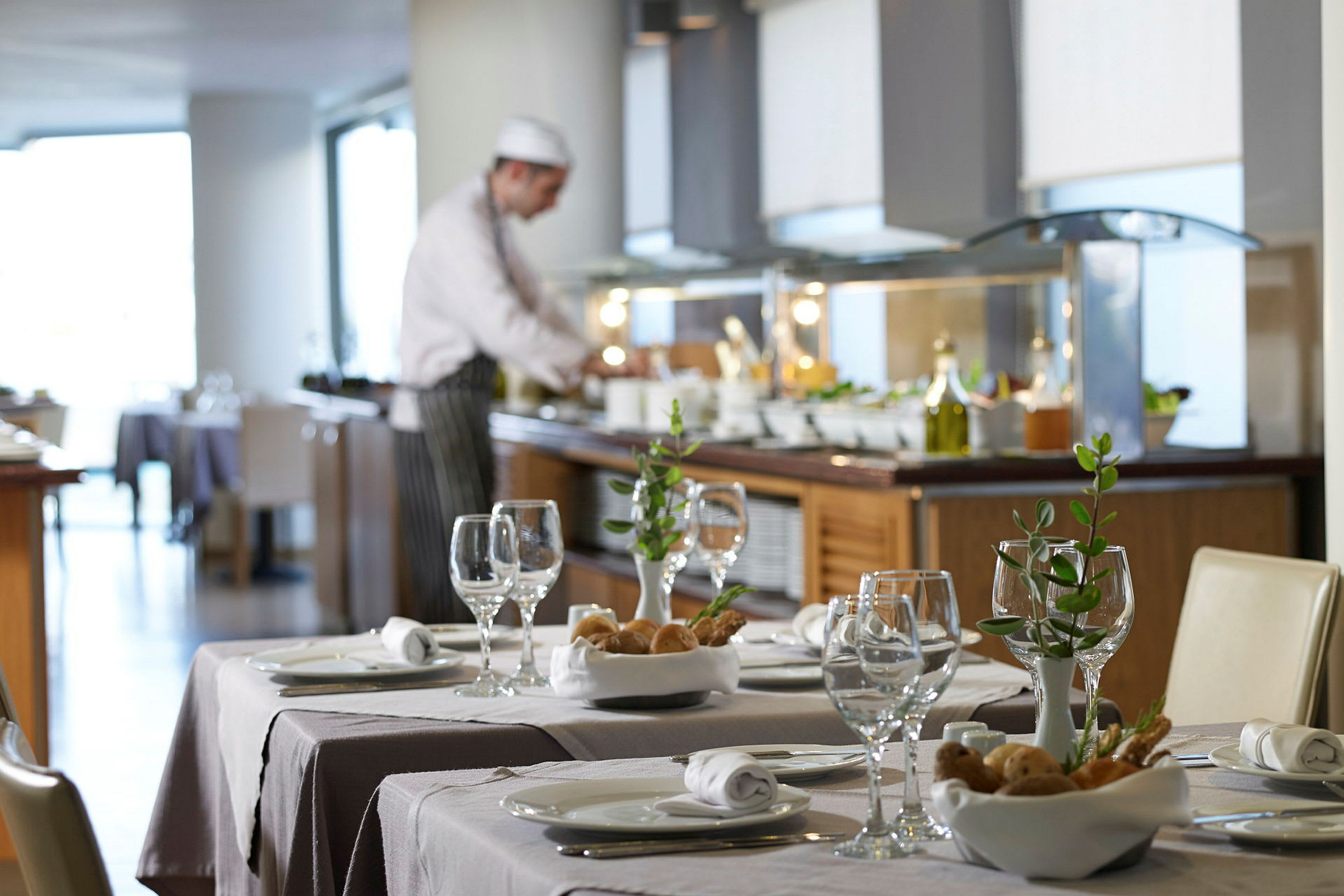 Liikeravintola, jossa on tyylikkäästi katettuja pöytiä ja buffet taustalla. (Tekoälyn luoma teksti)
