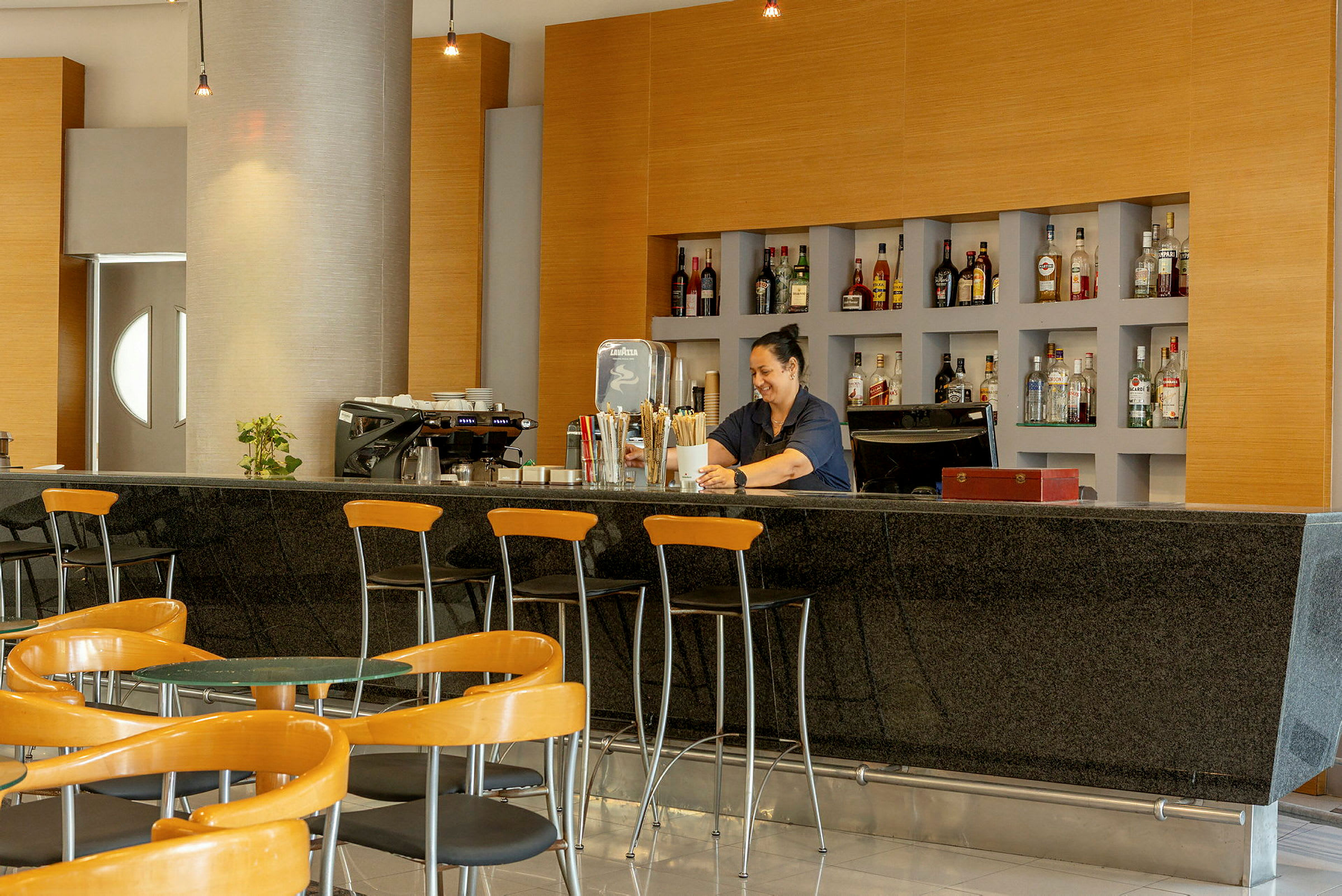 Hotellibaari, jossa istuma-alue ja hyllyt pulloineen. (Tekoälyn luoma teksti)