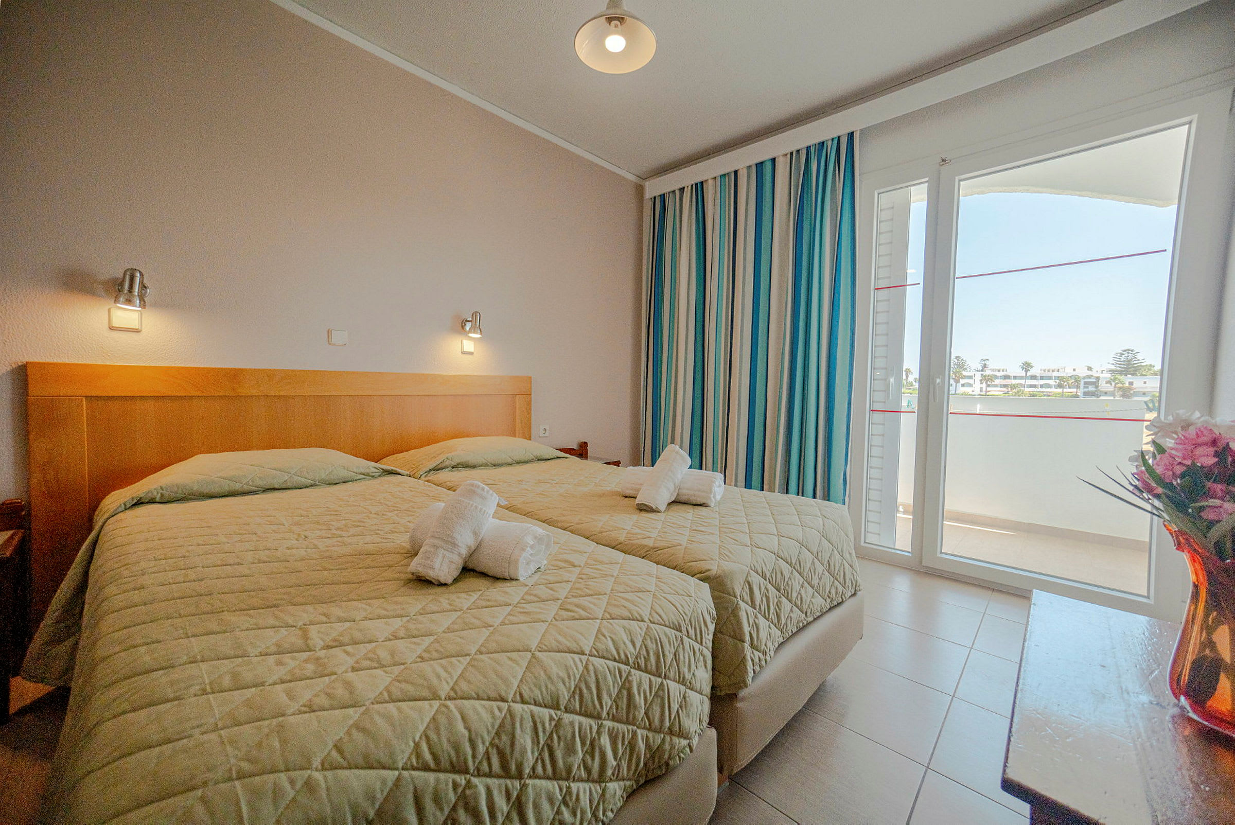 Hotellihuone, jossa kaksi erillistä vuodetta, ikkuna ja koristeita. (Tekoälyn luoma teksti)