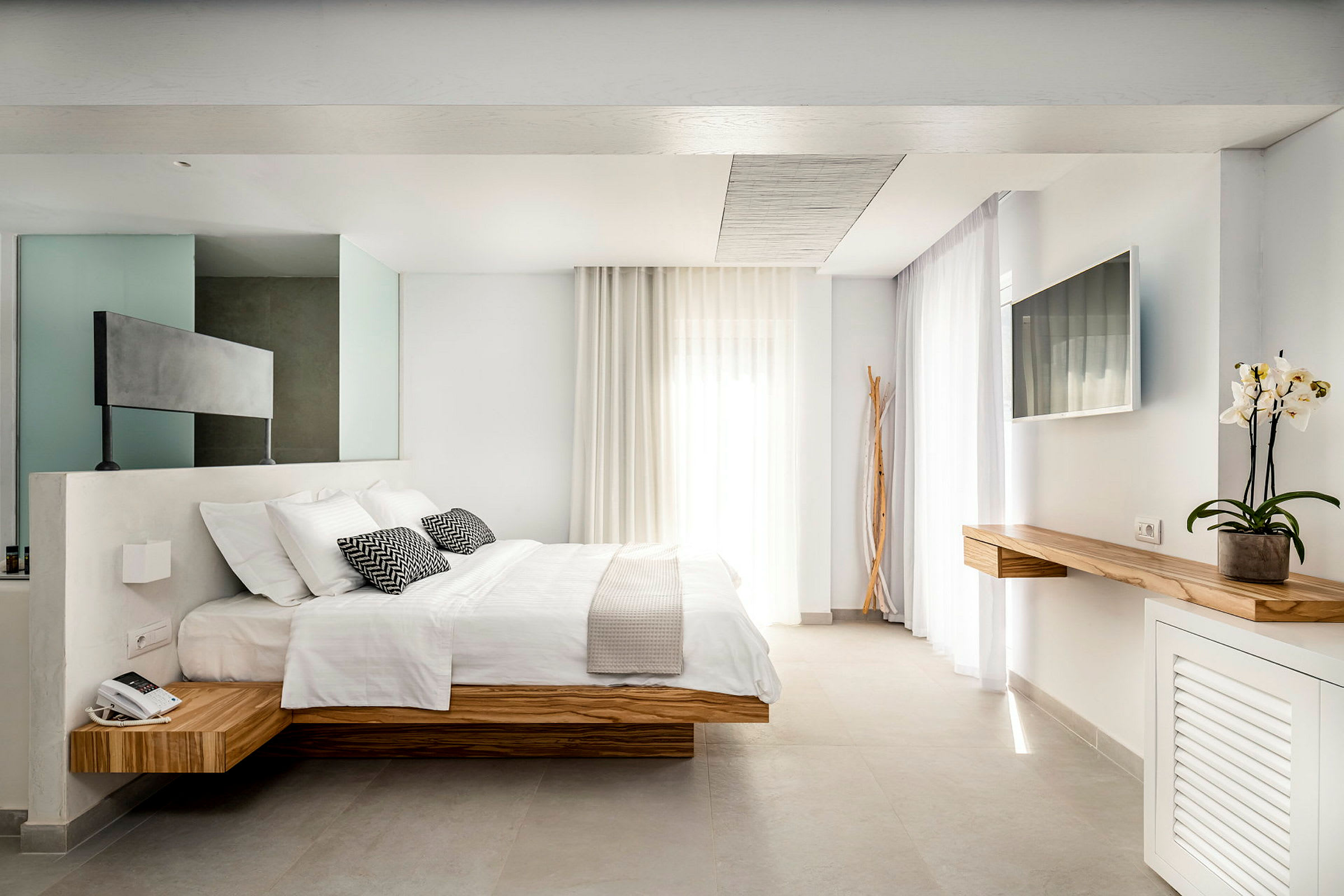 Moderni hotellihuone, jossa on parivuode ja minimalistinen sisustus. (Tekoälyn luoma teksti)