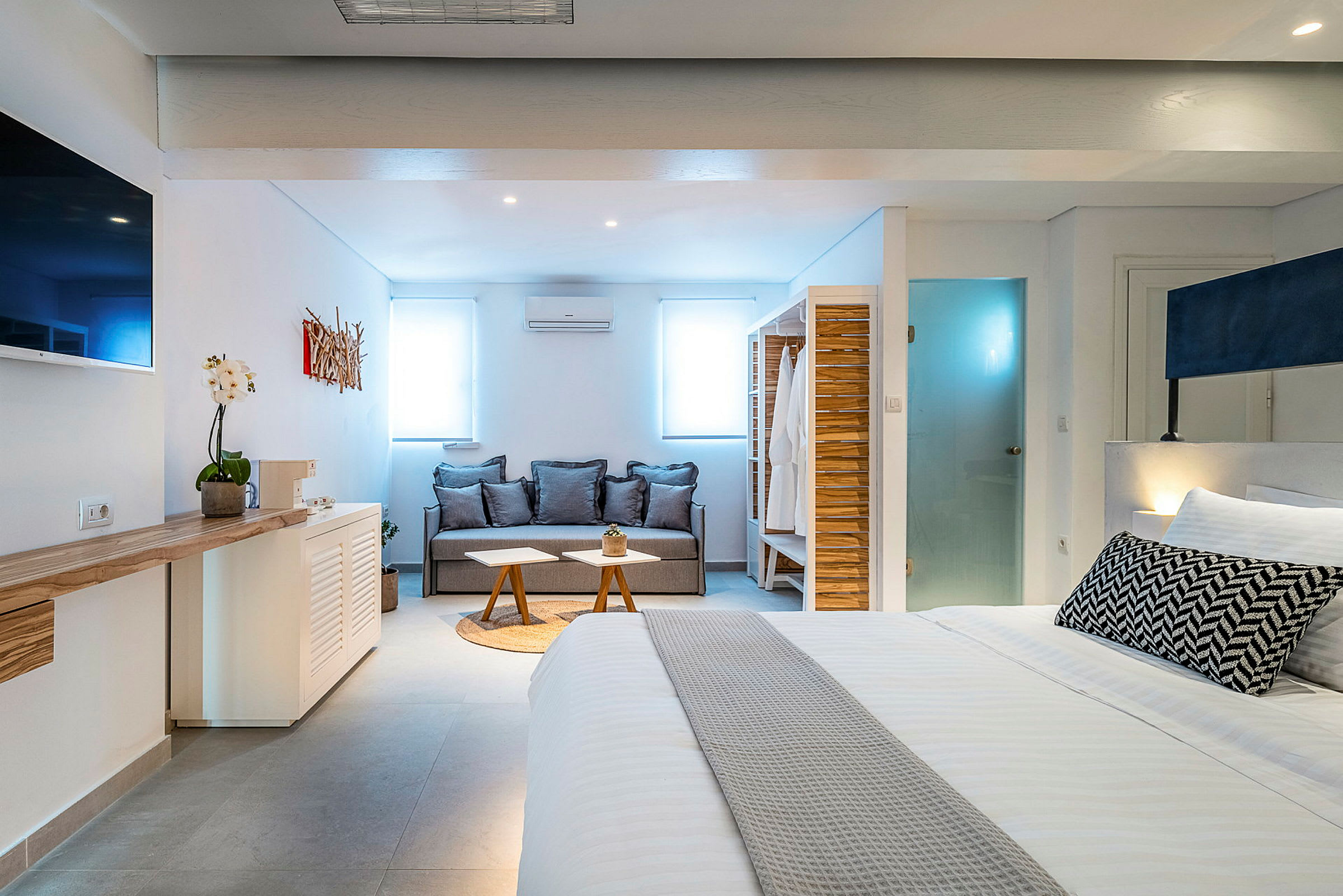 Modernisti sisustettu hotellihuone, jossa sohva ja sänky. (Tekoälyn luoma teksti)