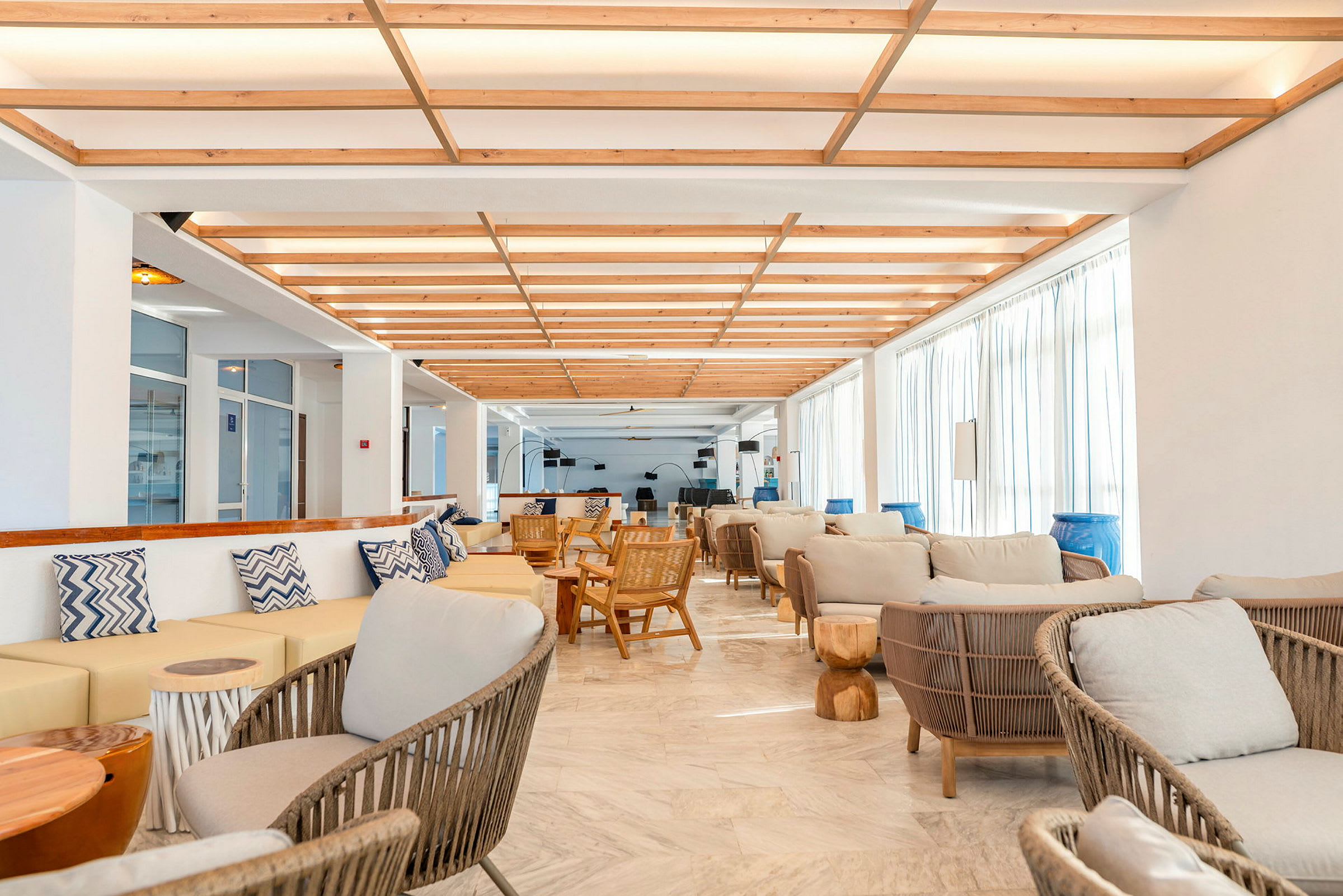 Valoisa ja moderni lounge-alue, jossa luonnonmateriaaleista valmistettuja huonekaluja. (Tekoälyn luoma teksti)