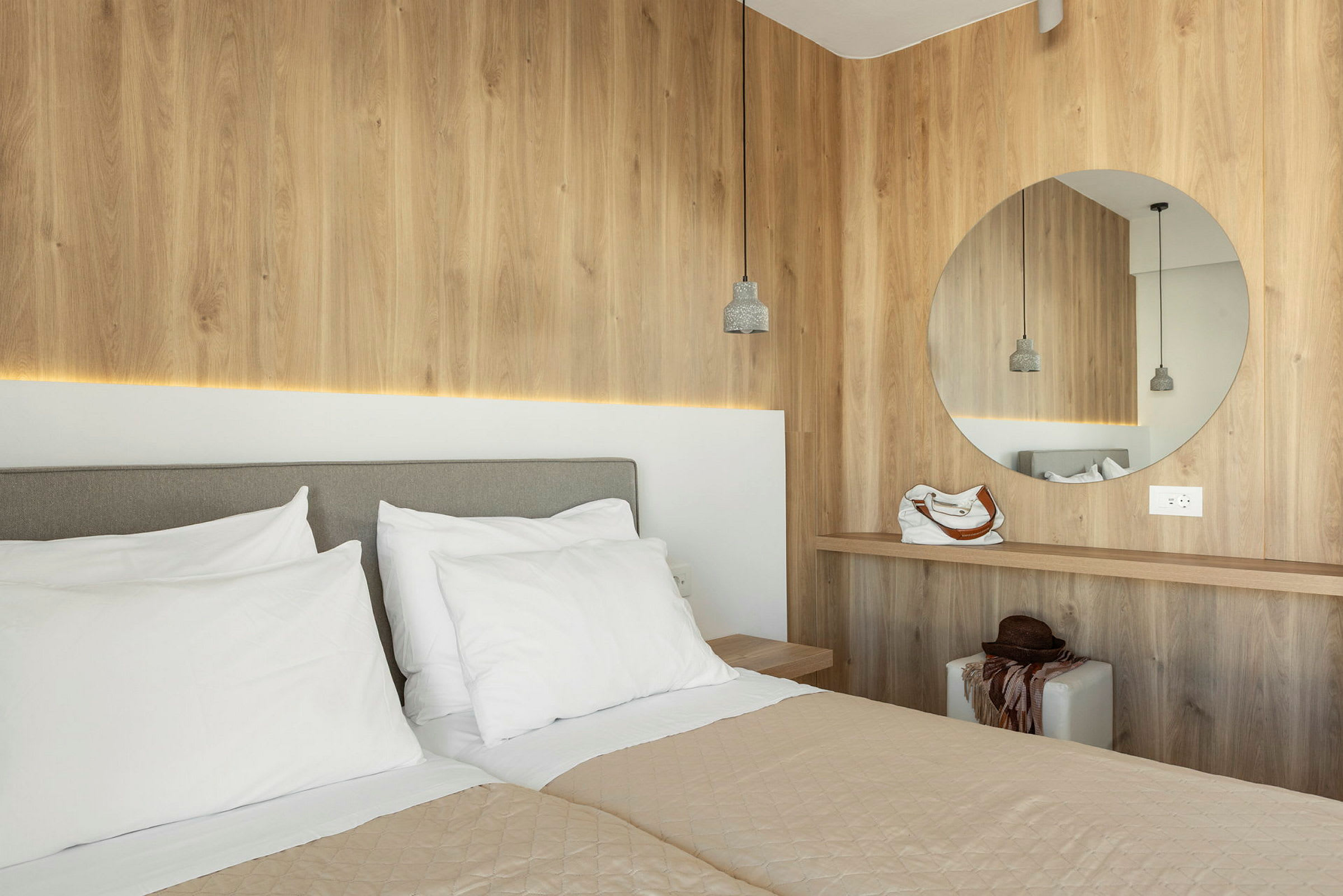 Moderni hotellihuone, jossa kaksi sänkyä ja puupaneelit. (Tekoälyn luoma teksti)