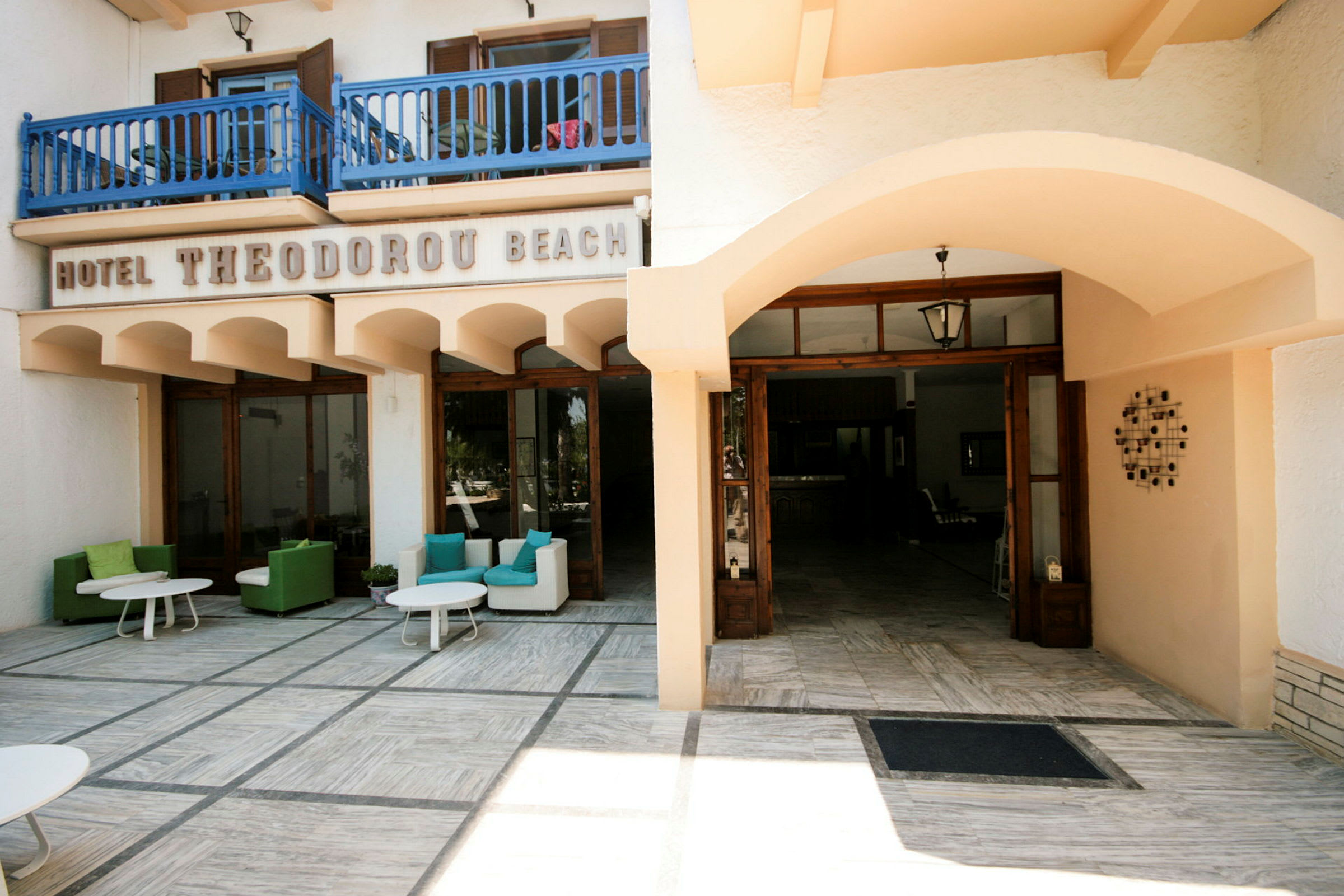 Hotel Theodoru Beachin sisäänkäynti ulkoistuinalueineen. (Tekoälyn luoma teksti)