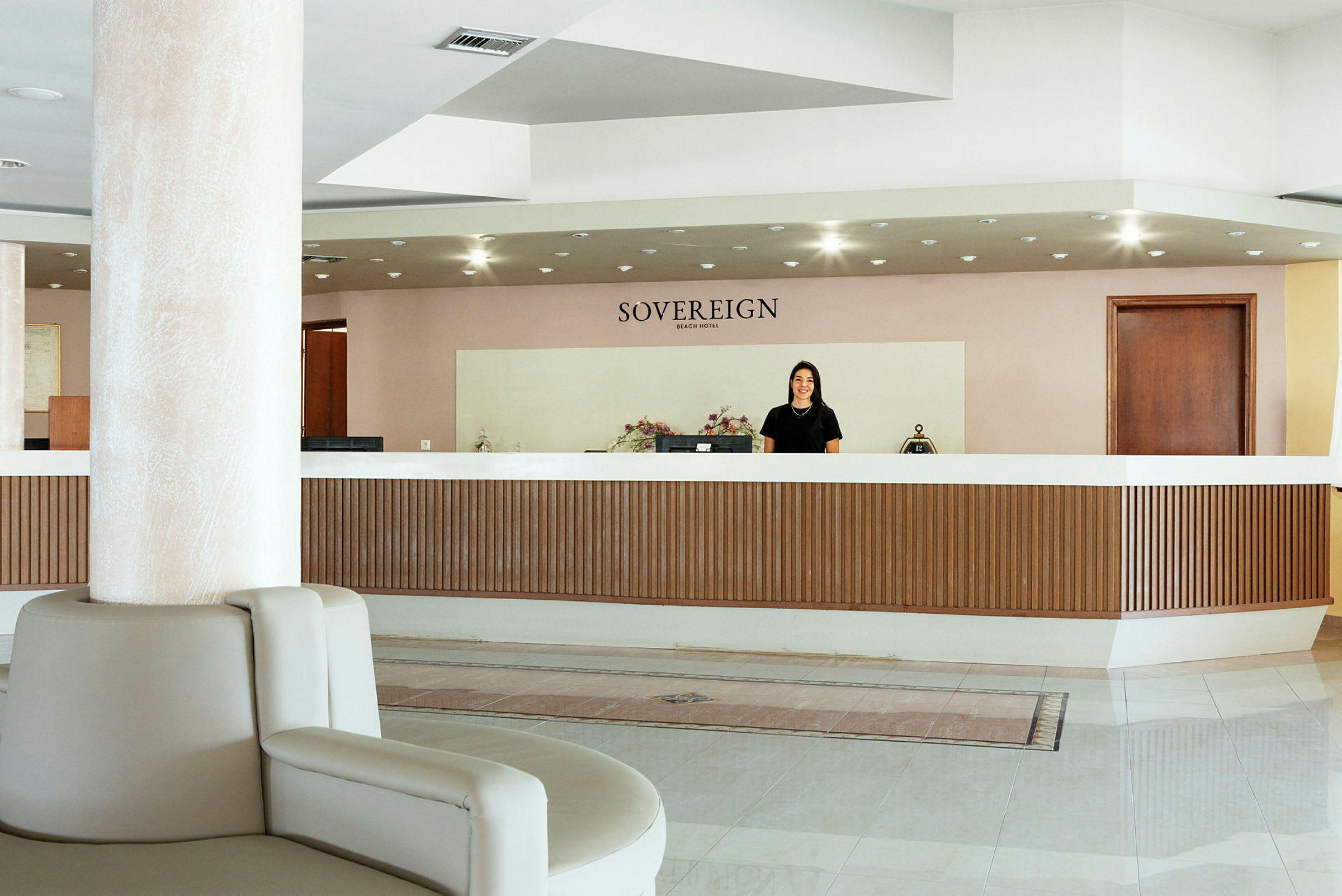 Hotellin vastaanotto, jossa ylhäällä lukee "Sovereign Beach Hotel". (Tekoälyn luoma teksti)