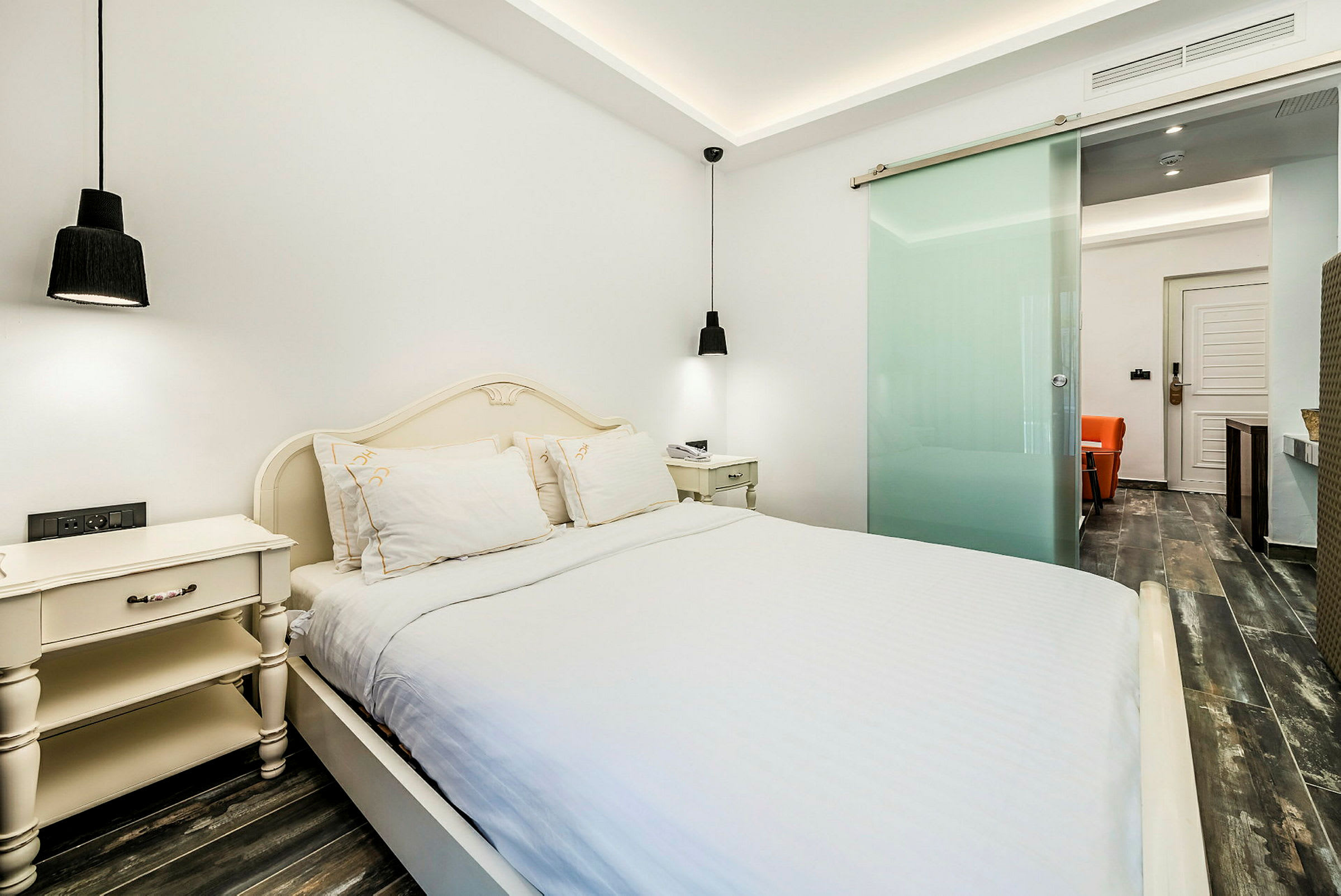 Hotellihuone, jossa on parivuode, yöpöydät ja modernit sisustuselementit. (Tekoälyn luoma teksti)