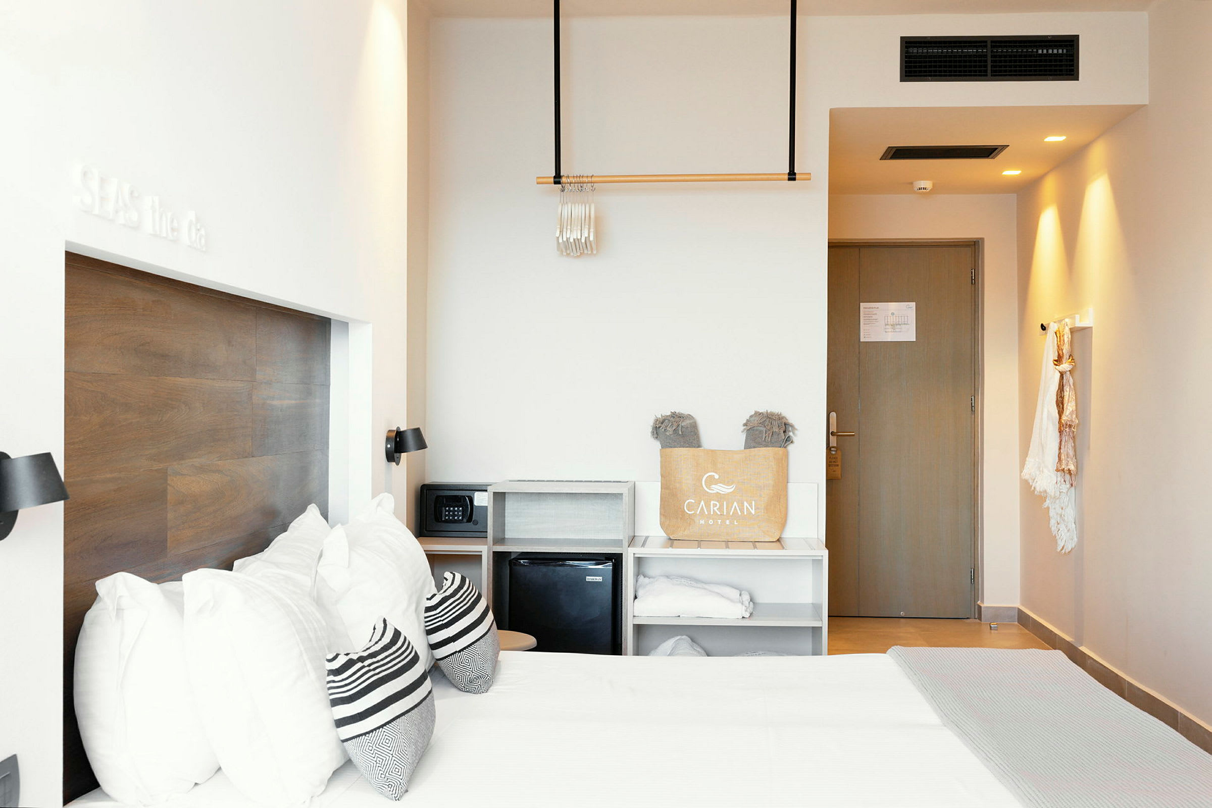 Hotellihuone, jossa on parivuode, seinällä puupaneeli, säilytyshyllyt ja ovi. (Tekoälyn luoma teksti)