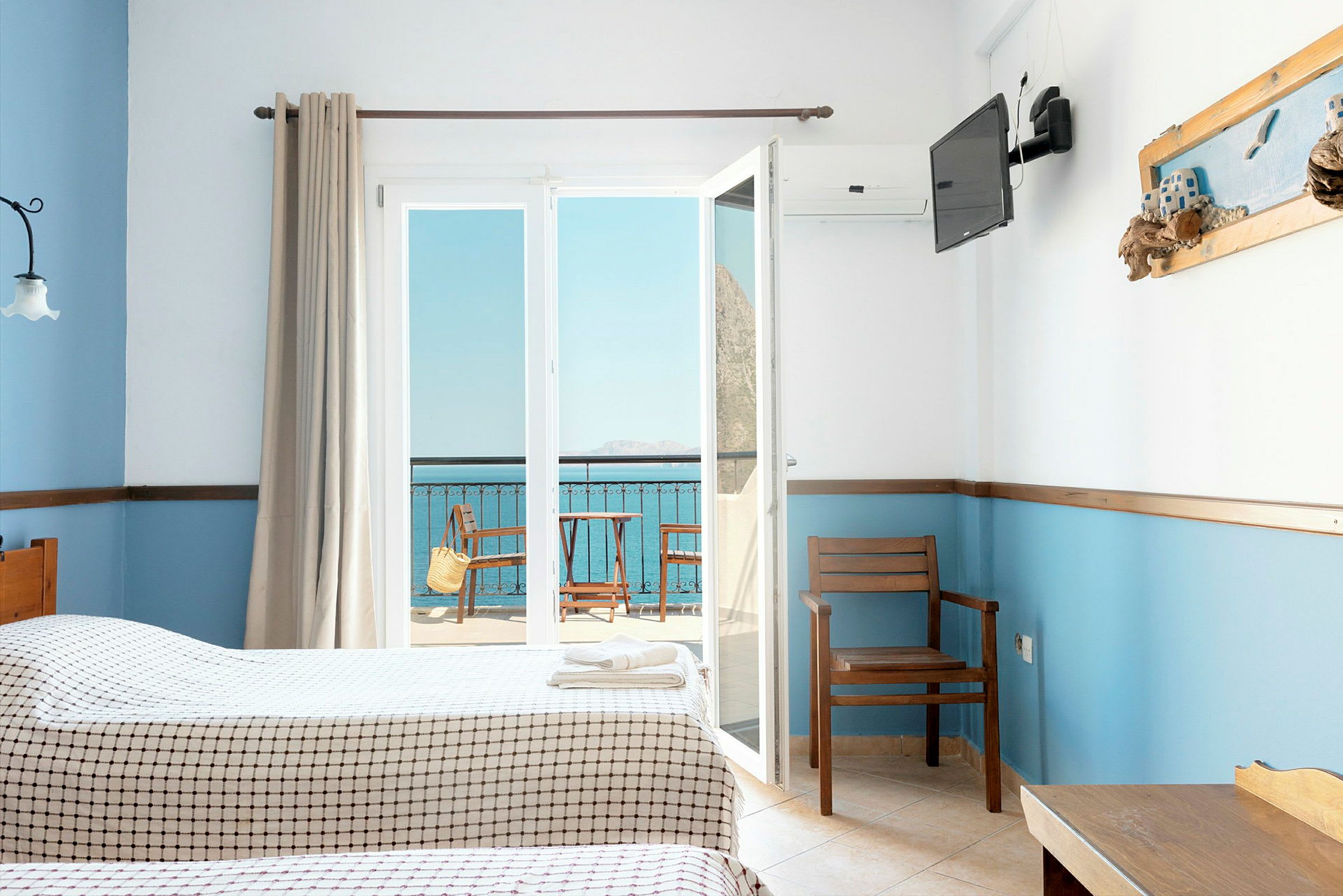 Hotellihuone, jossa kaksi sänkyä, näkymä parvekkeelle ja merelle. (Tekoälyn luoma teksti)