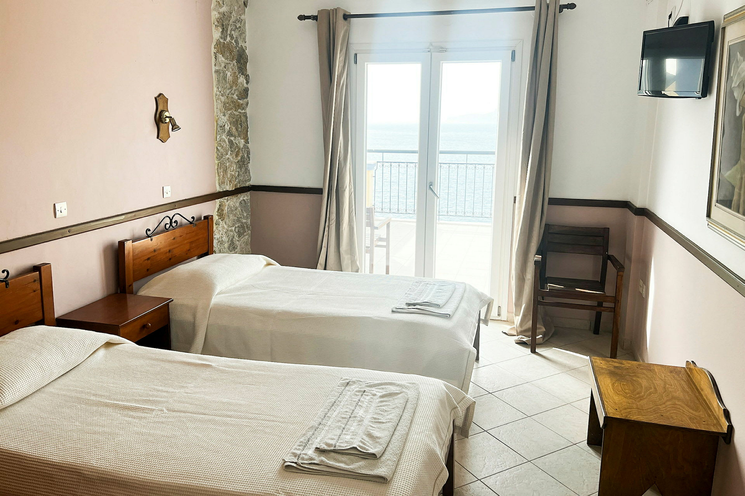 Hotellihuone, jossa kaksi yhden hengen sänkyä ja ikkuna merinäköalalla. (Tekoälyn luoma teksti)