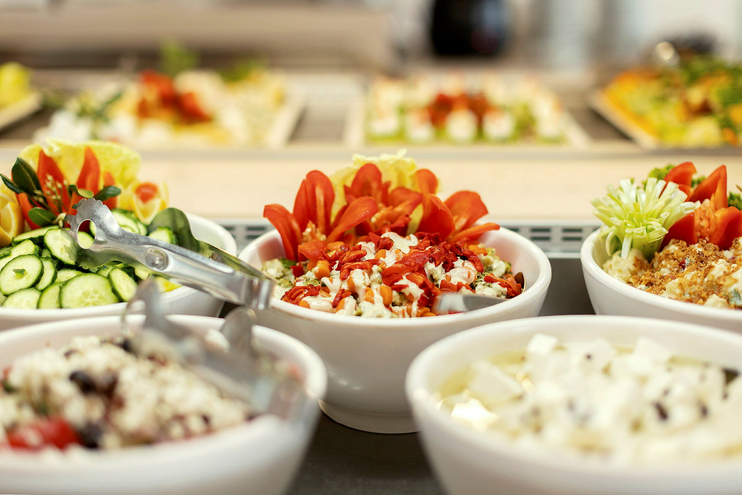 Buffet, jossa on erilaisia salaatteja ja lisukkeita. (Tekoälyn luoma teksti)