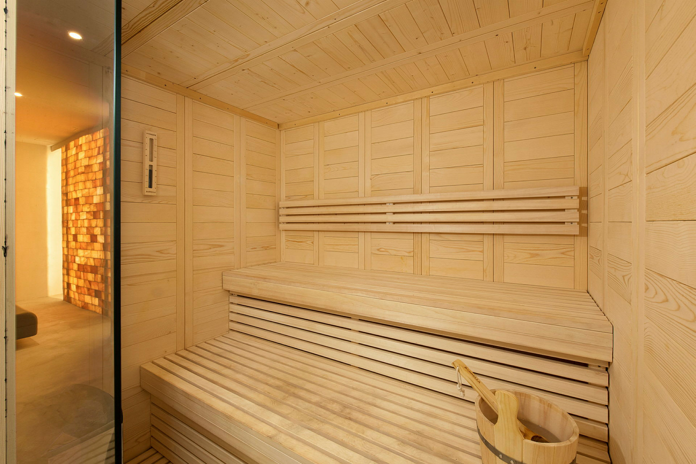 Moderni sauna, jossa on puusisustus ja istuimia. (Tekoälyn luoma teksti)