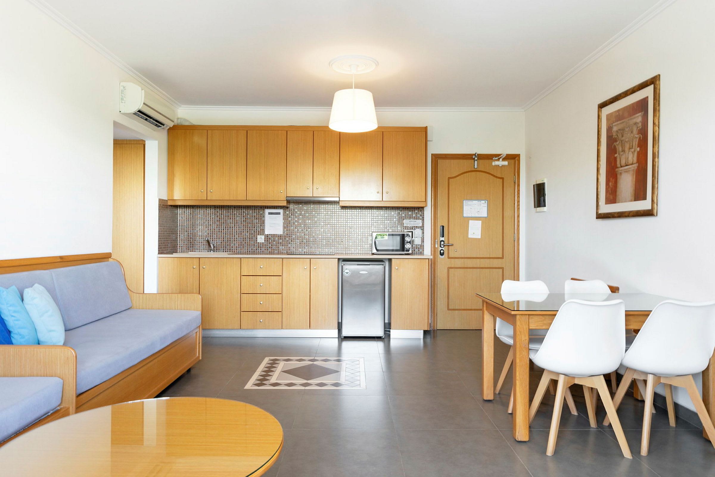 Hotellihuone, jossa on keittiö, ruokapöytä ja sohva. (Tekoälyn luoma teksti)