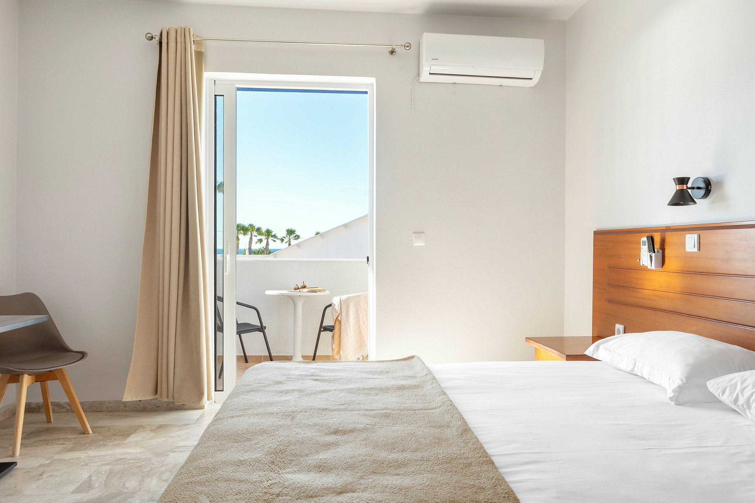 Hotellihuone, jossa on sänky ja parveke. (Tekoälyn luoma teksti)