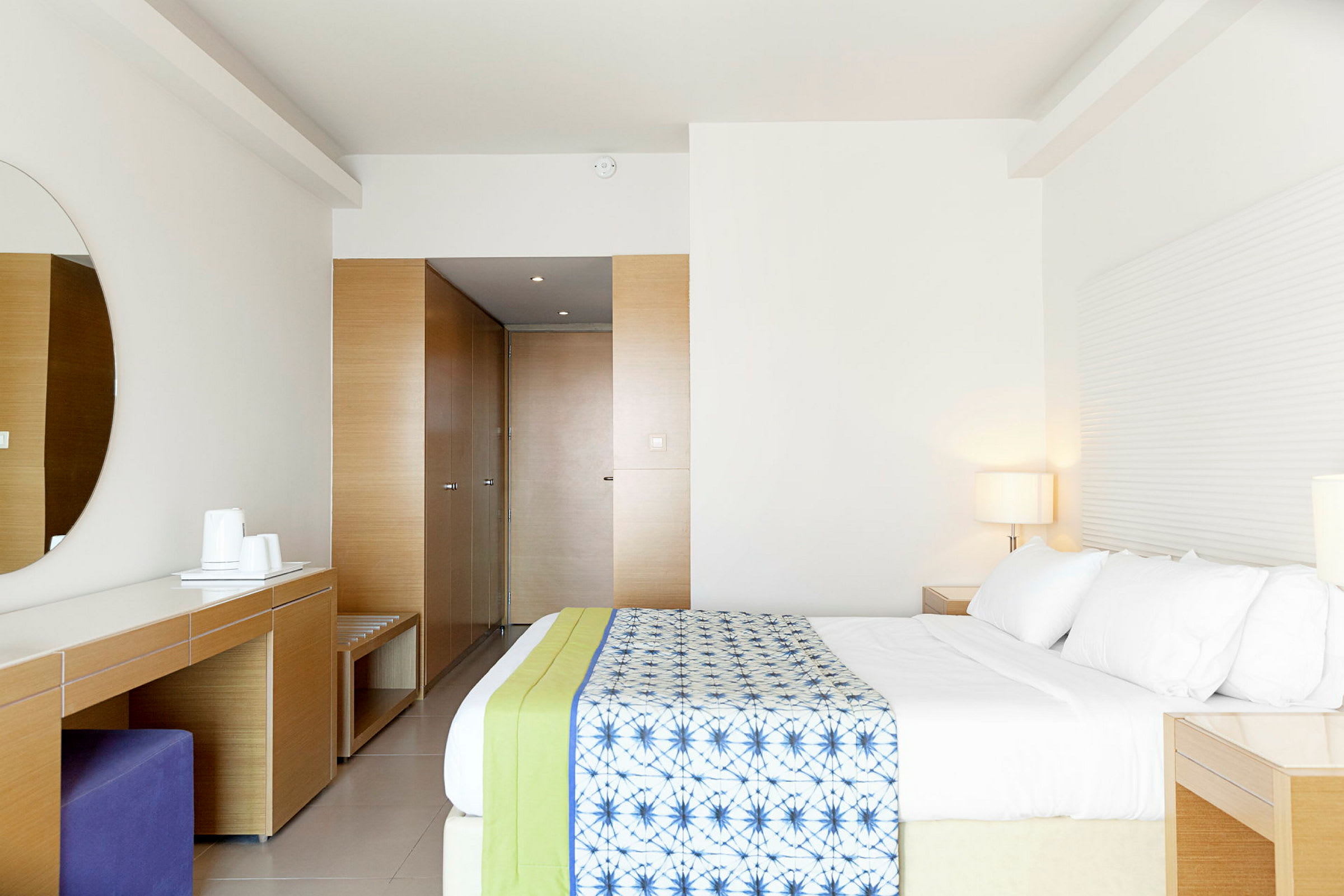 Moderni hotellihuone, jossa tilava sänky ja minimalistinen sisustus. (Tekoälyn luoma teksti)