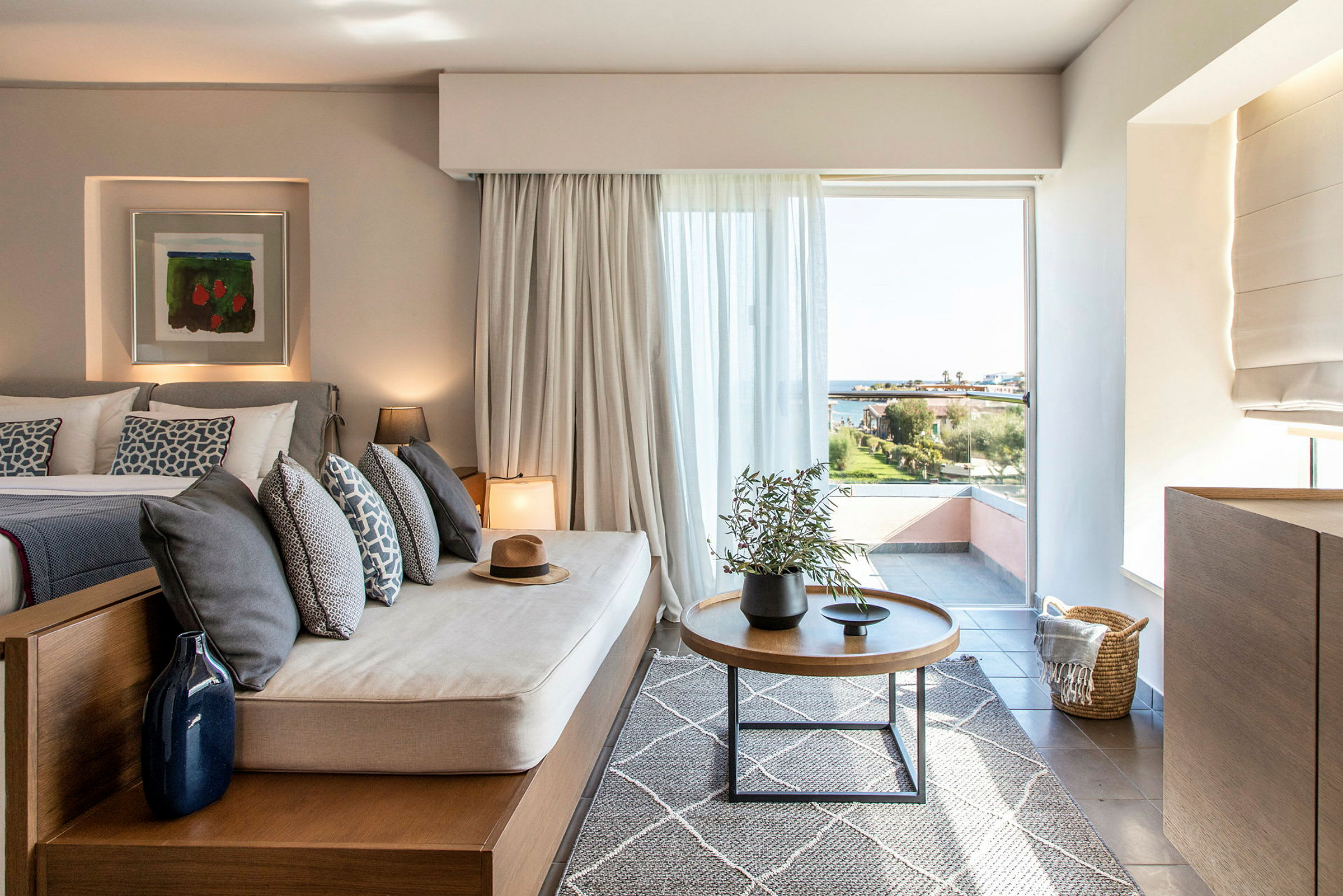 Kuva nykyaikaisesta hotellihuoneesta, jossa on istuin ja näkymä maisemaan suuren ikkunan kautta. (Tekoälyn luoma teksti)