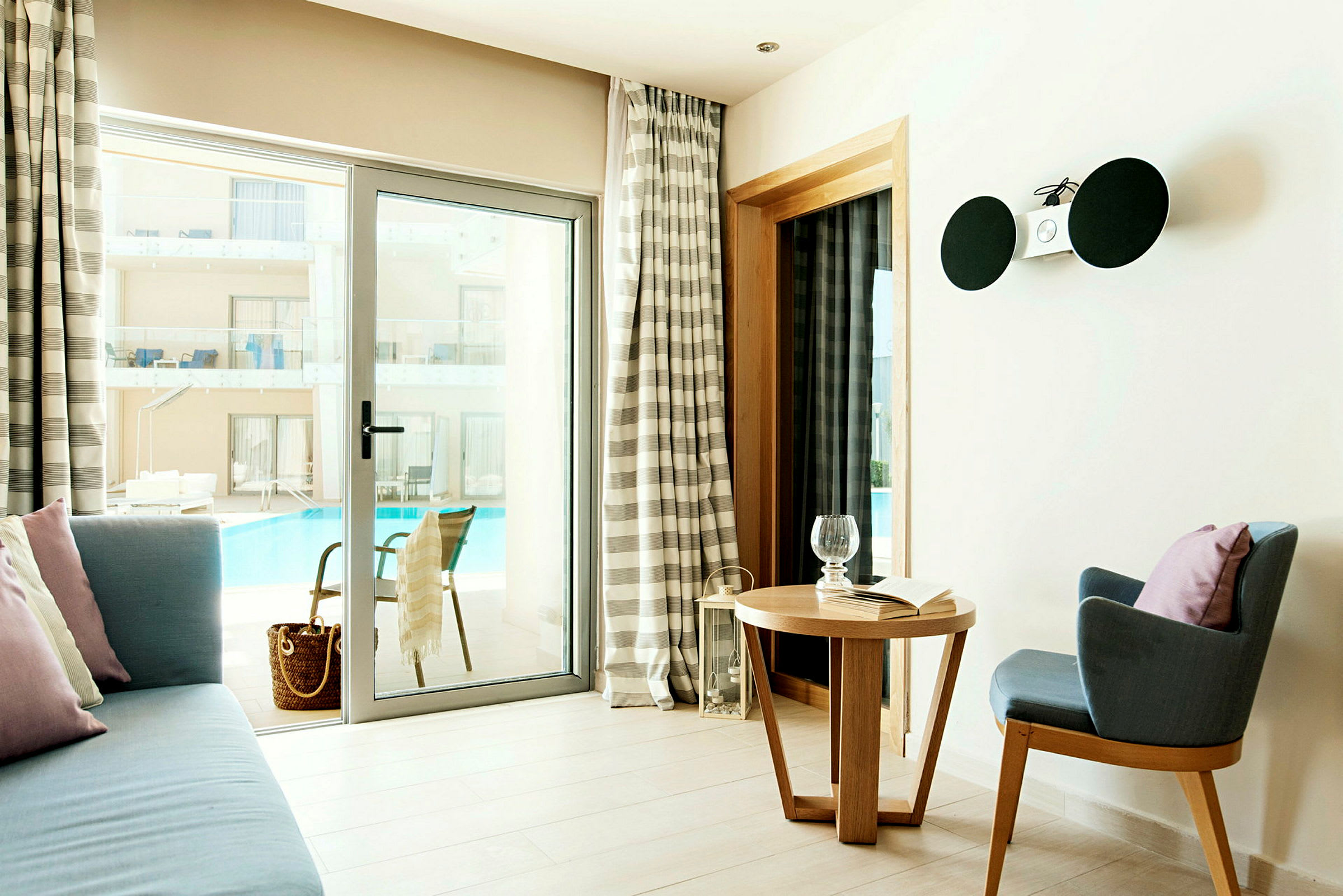 Hotellihuone, jossa istuinalue ja näkymä altaalle. (Tekoälyn luoma teksti)