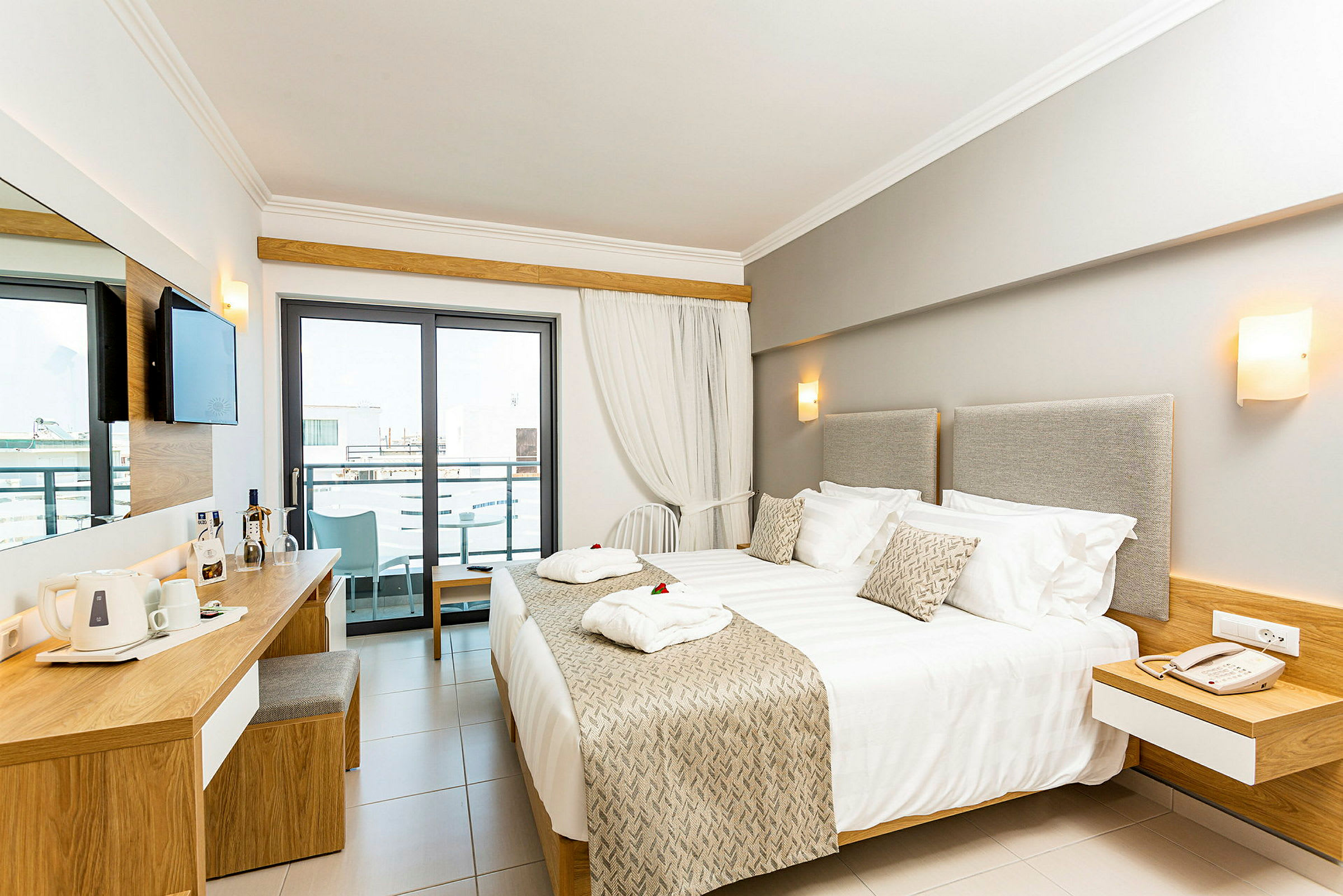 Moderni hotellihuone, jossa on parivuode, kirjoituspöytä ja parveke. (Tekoälyn luoma teksti)