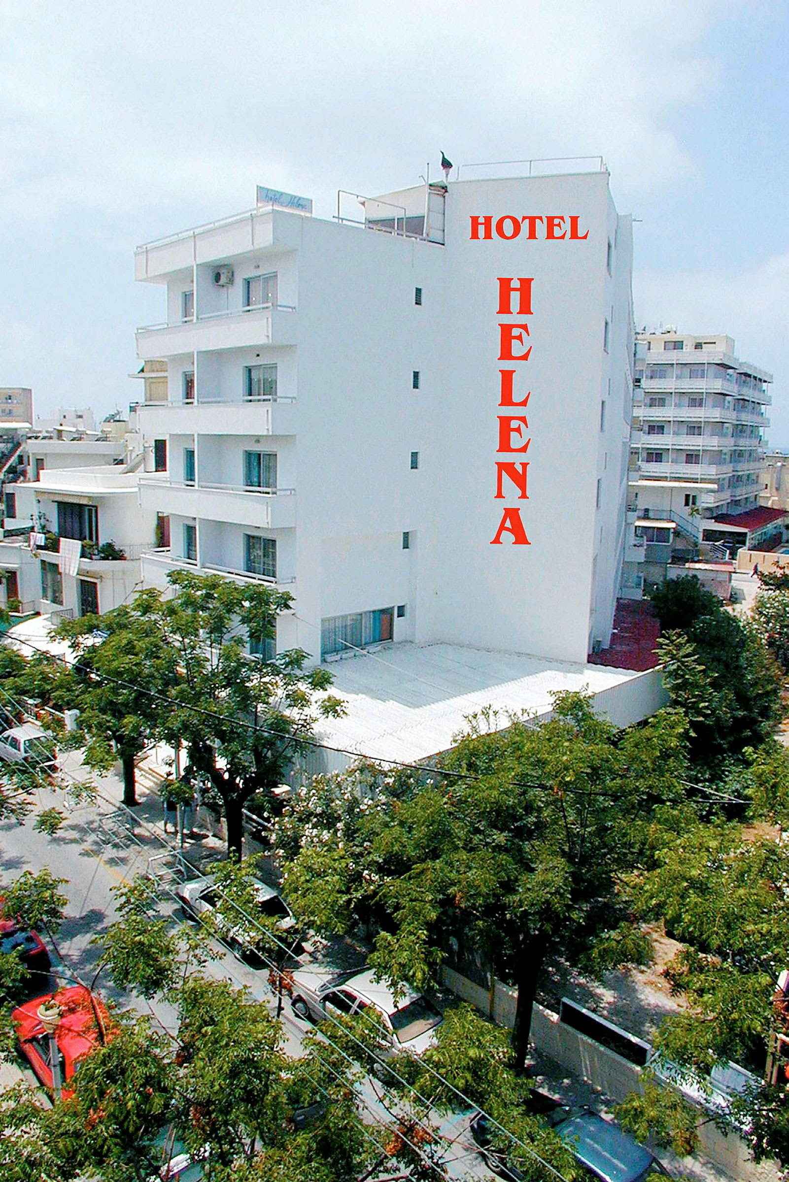 Valkoinen hotellirakennus, jossa nimi 'Hotel Helena' kirjoitettu punaisilla kirjaimilla. (Tekoälyn luoma teksti)