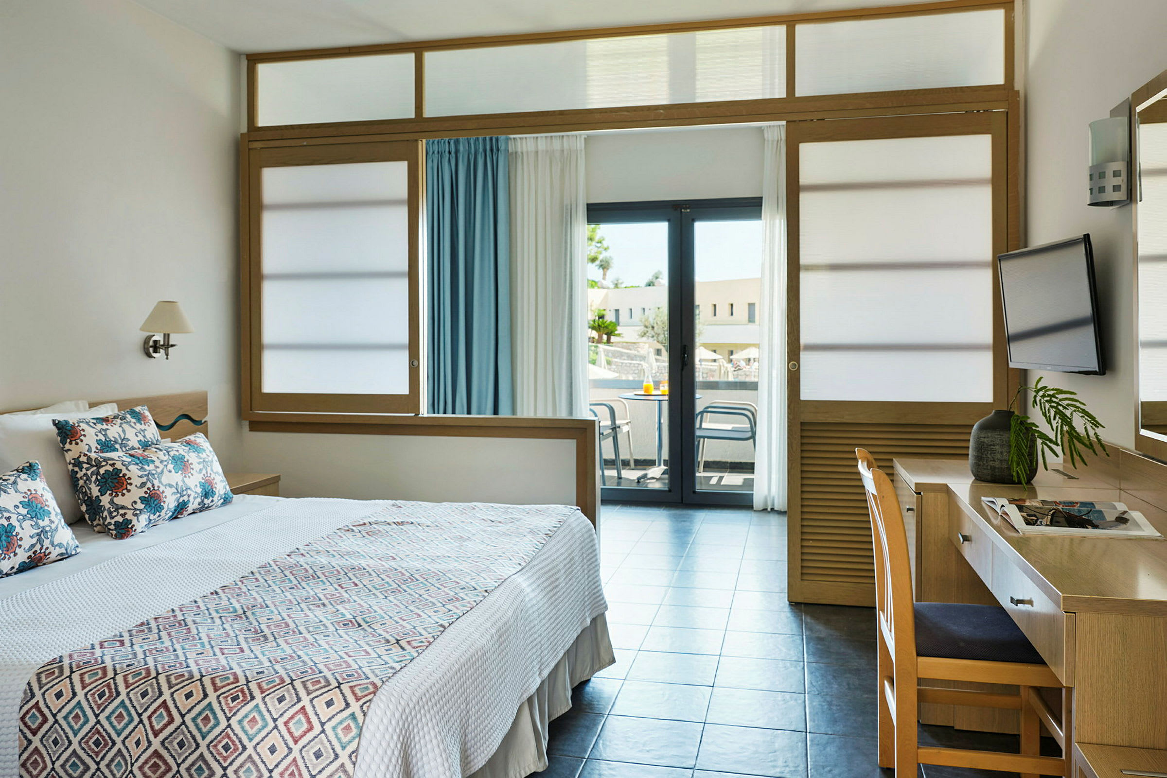 Hotellihuone, jossa sänky, kirjoituspöytä ja parveke. (Tekoälyn luoma teksti)