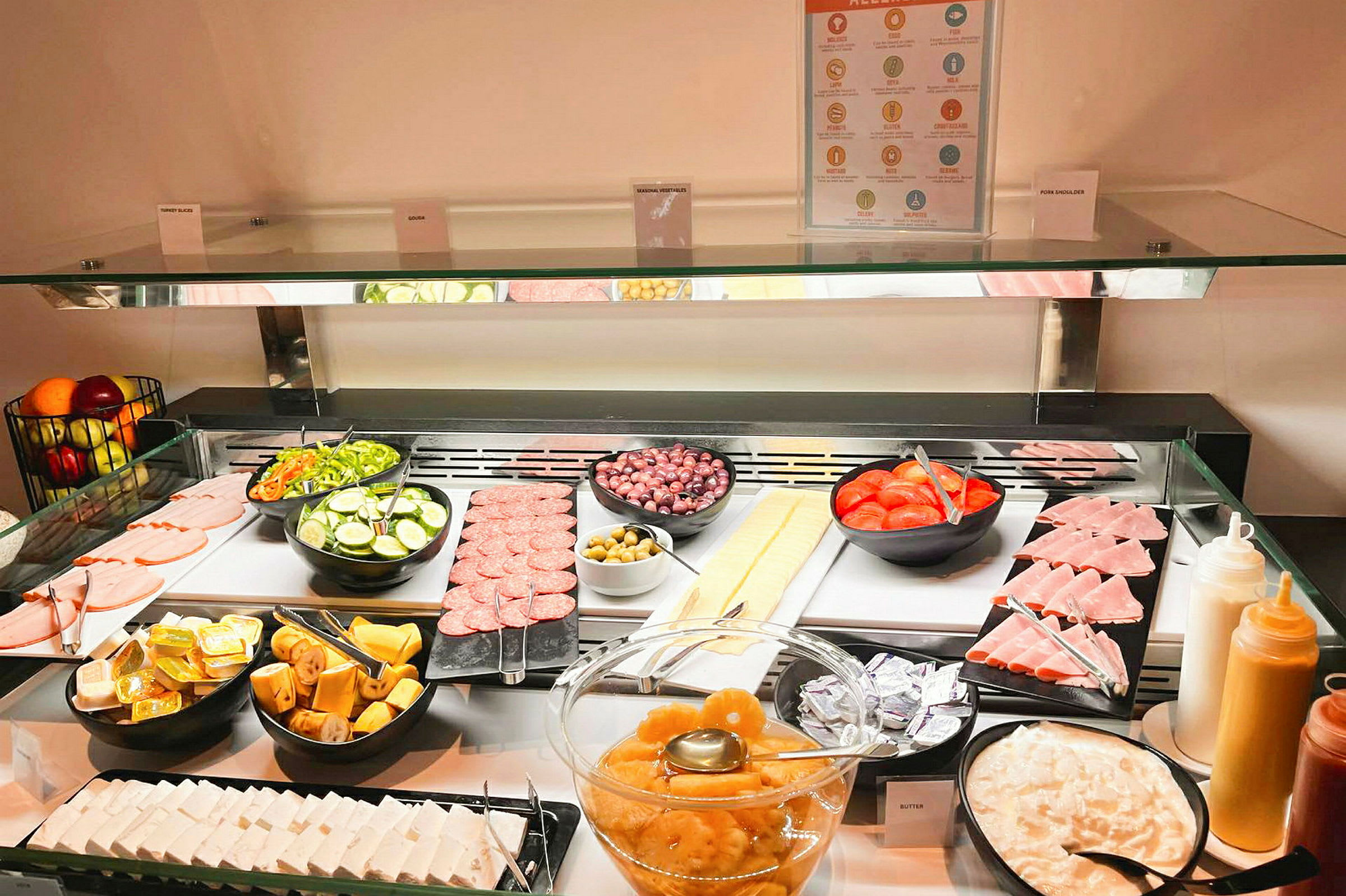 Buffet, jossa on viipaloituja vihanneksia, lihatuotteita, hedelmiä ja erilaisia lisukkeita. (Tekoälyn luoma teksti)
