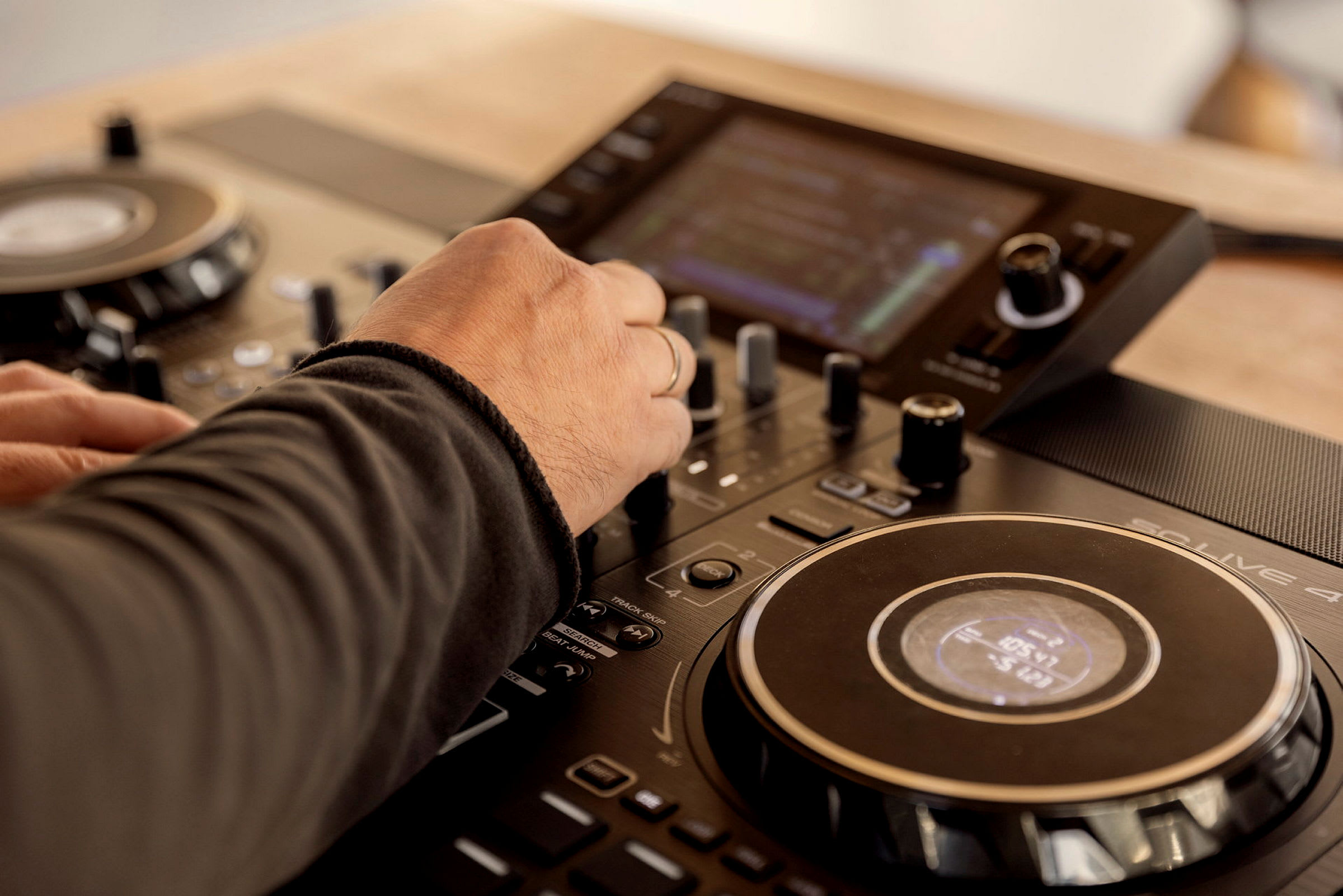 Käsi säätää DJ-sekoittimen säätimiä. (Tekoälyn luoma teksti)