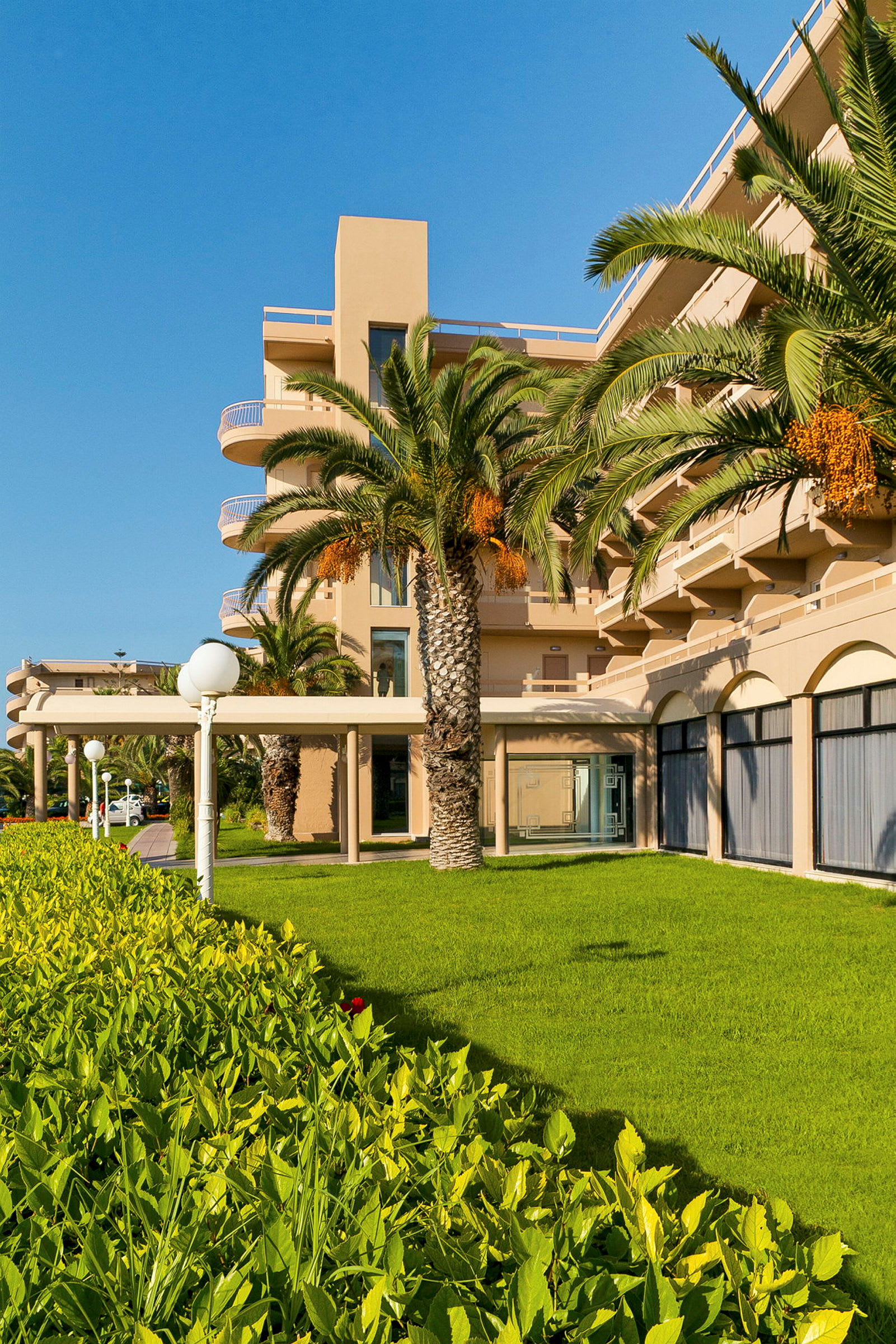 Hotellirakennus palmuilla ja vihreällä puutarhalla. (Tekoälyn luoma teksti)