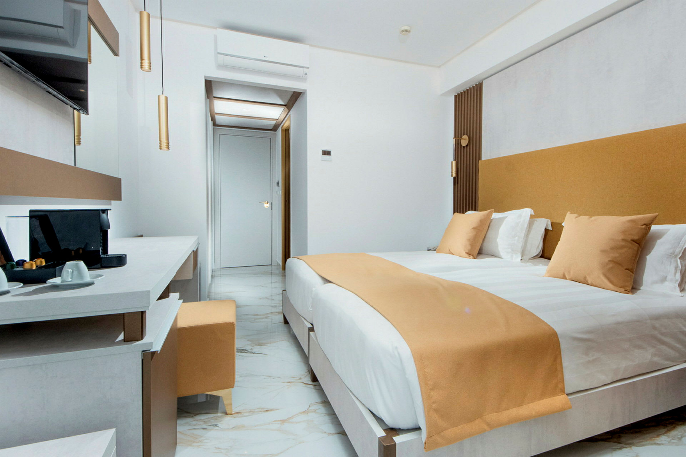 Moderni hotellihuone, jossa suuri sänky, marmorialattia ja työtila kahvinkeittimellä. (Tekoälyn luoma teksti)